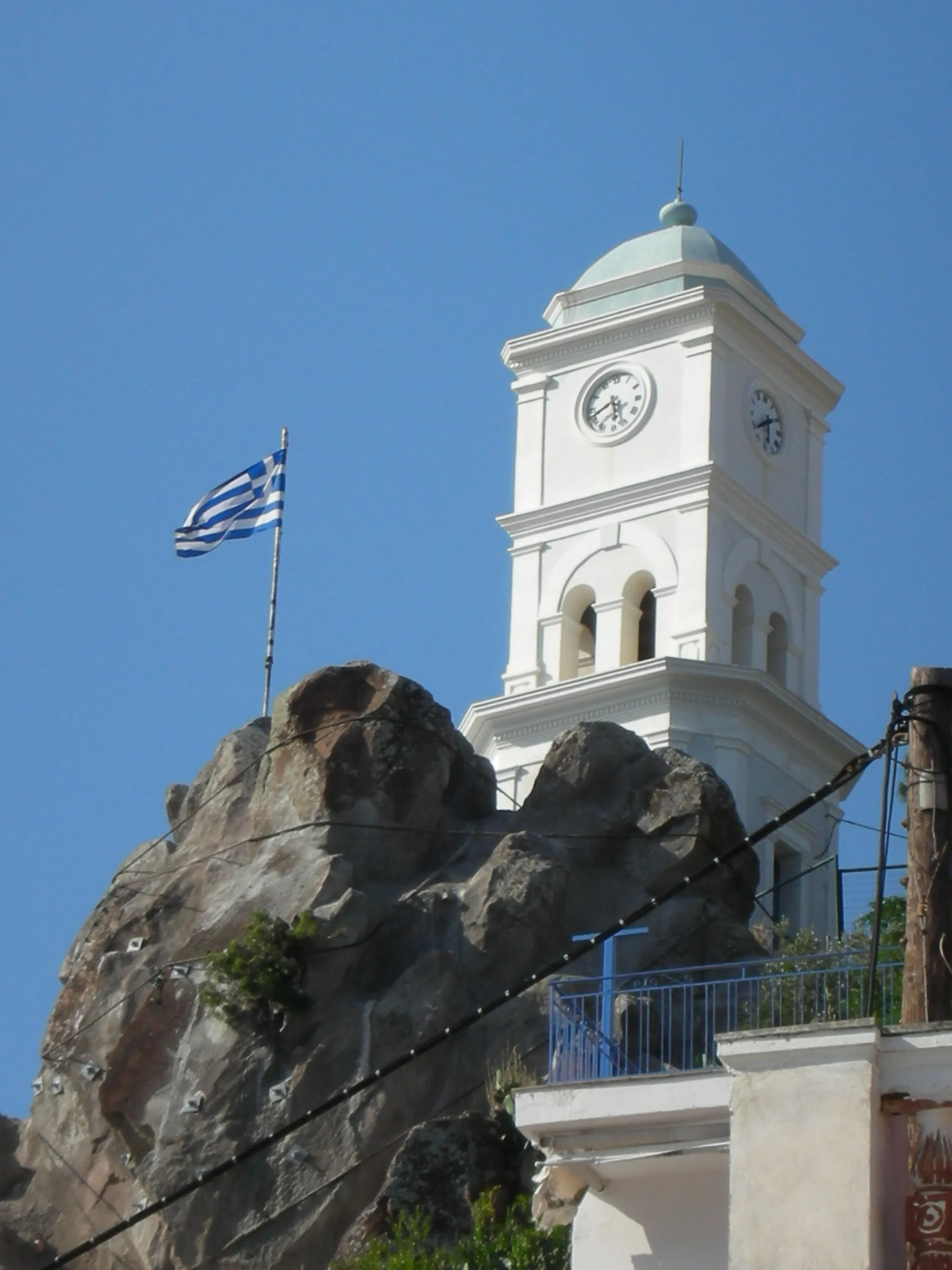 Photo showing: Clock tower, Poros Island, the Saronic Gulf Islands (Gulf of Aegina), Greece. The picturesque town of Poros with its beautiful neoclassical buildings is built amphitheatrically on the slopes of a hill. Its most famous landmark is a clock tower, built in 1927.