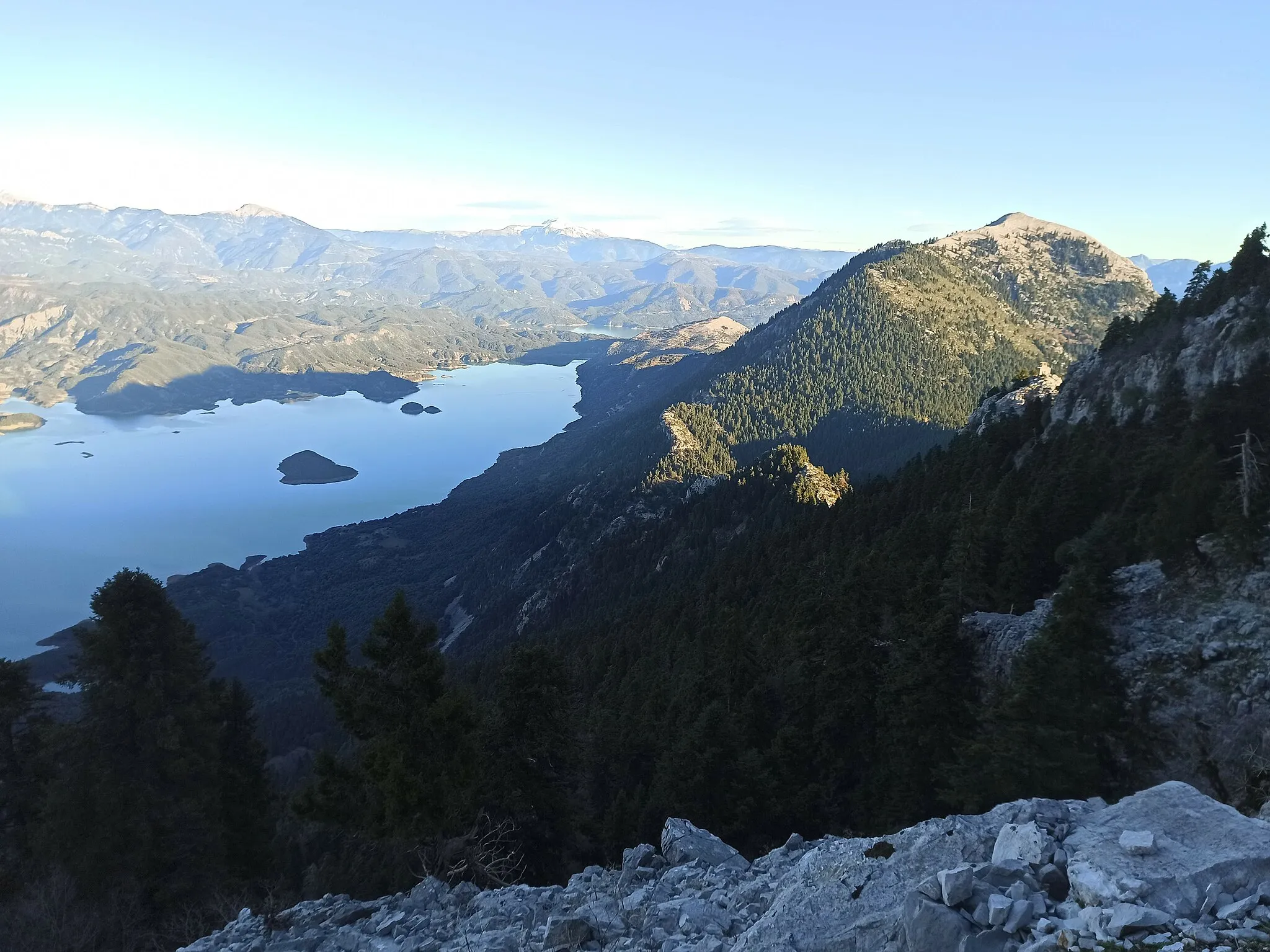 Photo showing: Mount Kalana Lake Kremaston. The photo was taken from the path that connects the observatory with the cave of Agios Andreas the Hermit approaching the cave. The observatory can be seen to the right of the middle peak between the two highest peaks.