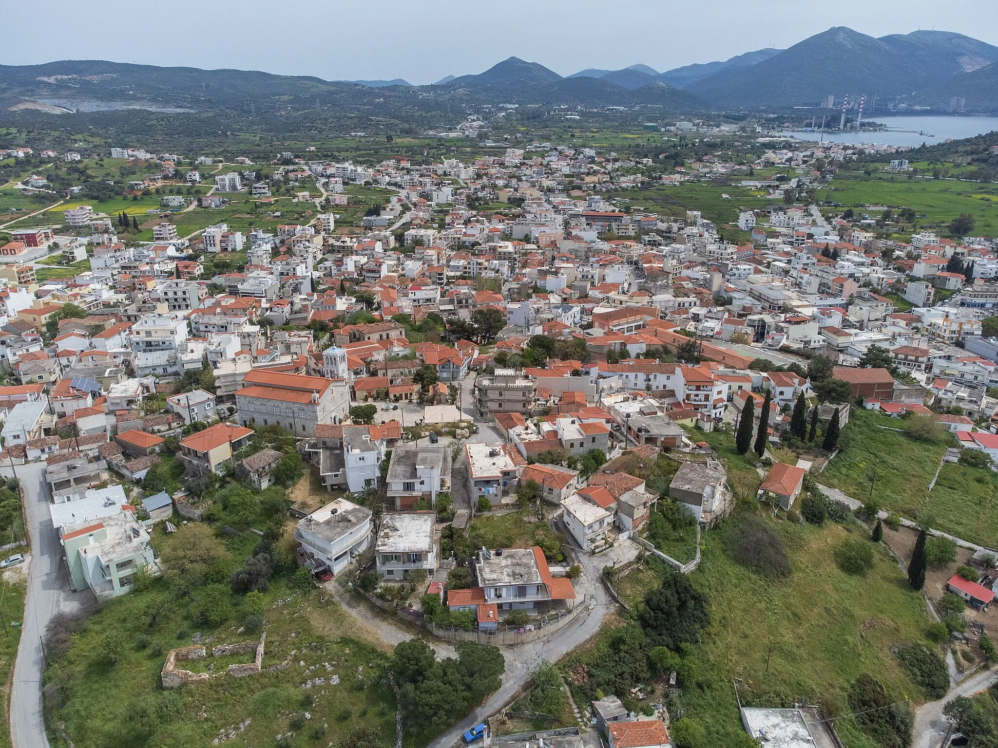 Photo showing: Aerial view of Aliveri, Euboea. On the small hill on the foreground lies the old part of the town and the background can be seen Karavos, where the electricity plant is located.
