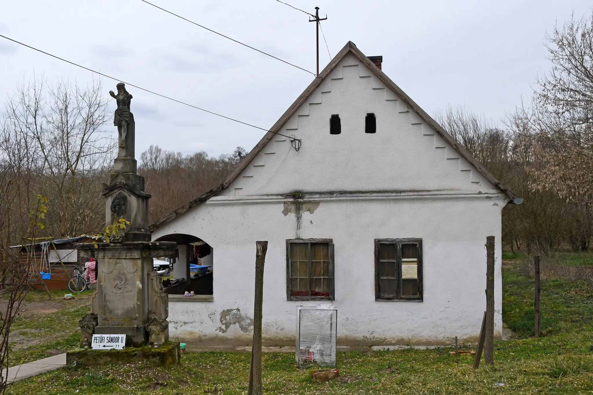 Photo showing: Vernacular house at the northern tip of Pamuk, Hungary with a stone cross