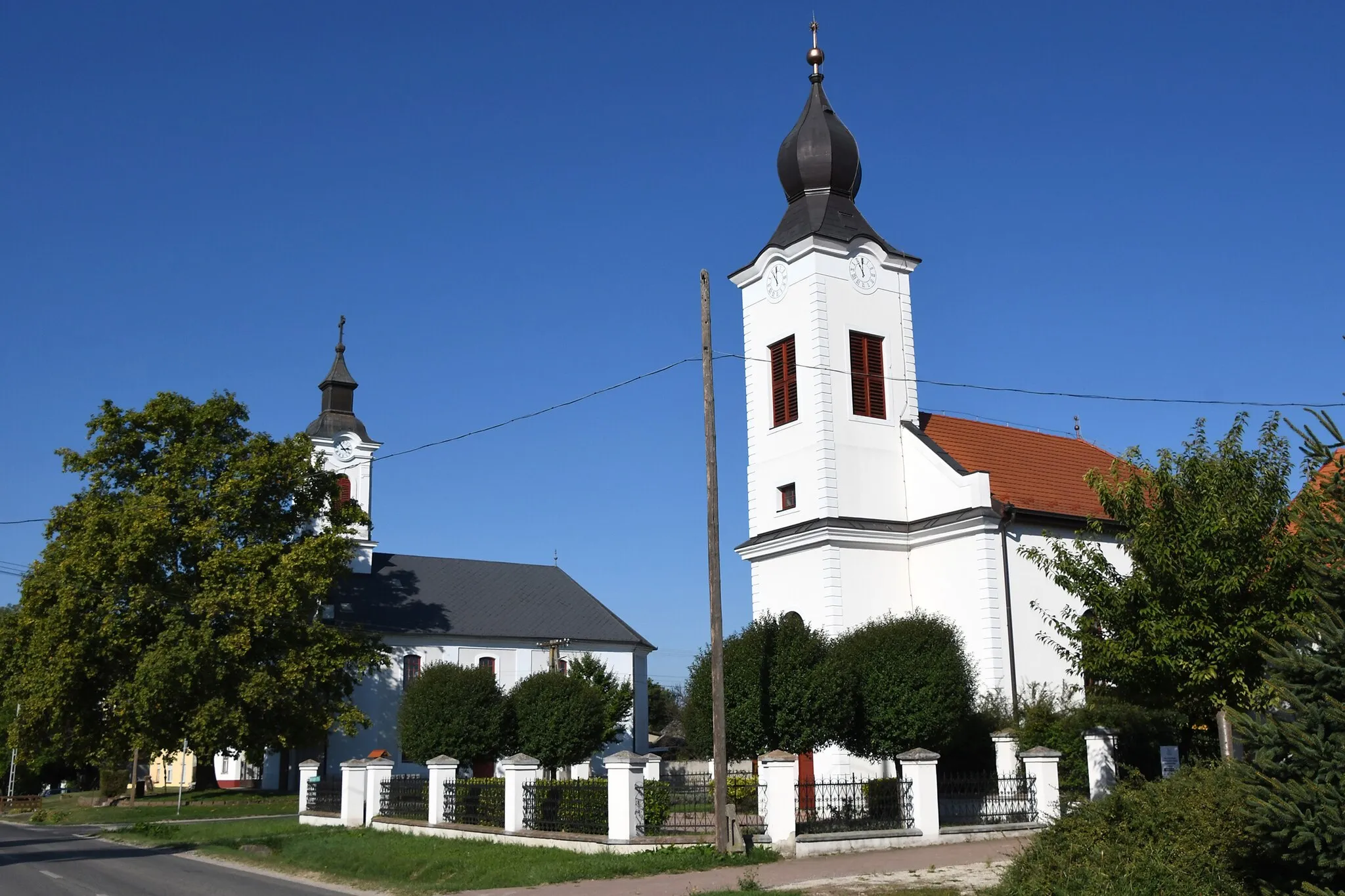 Photo showing: Calvinist church in Lajoskomárom, Hungary with the Lutheran church in the background