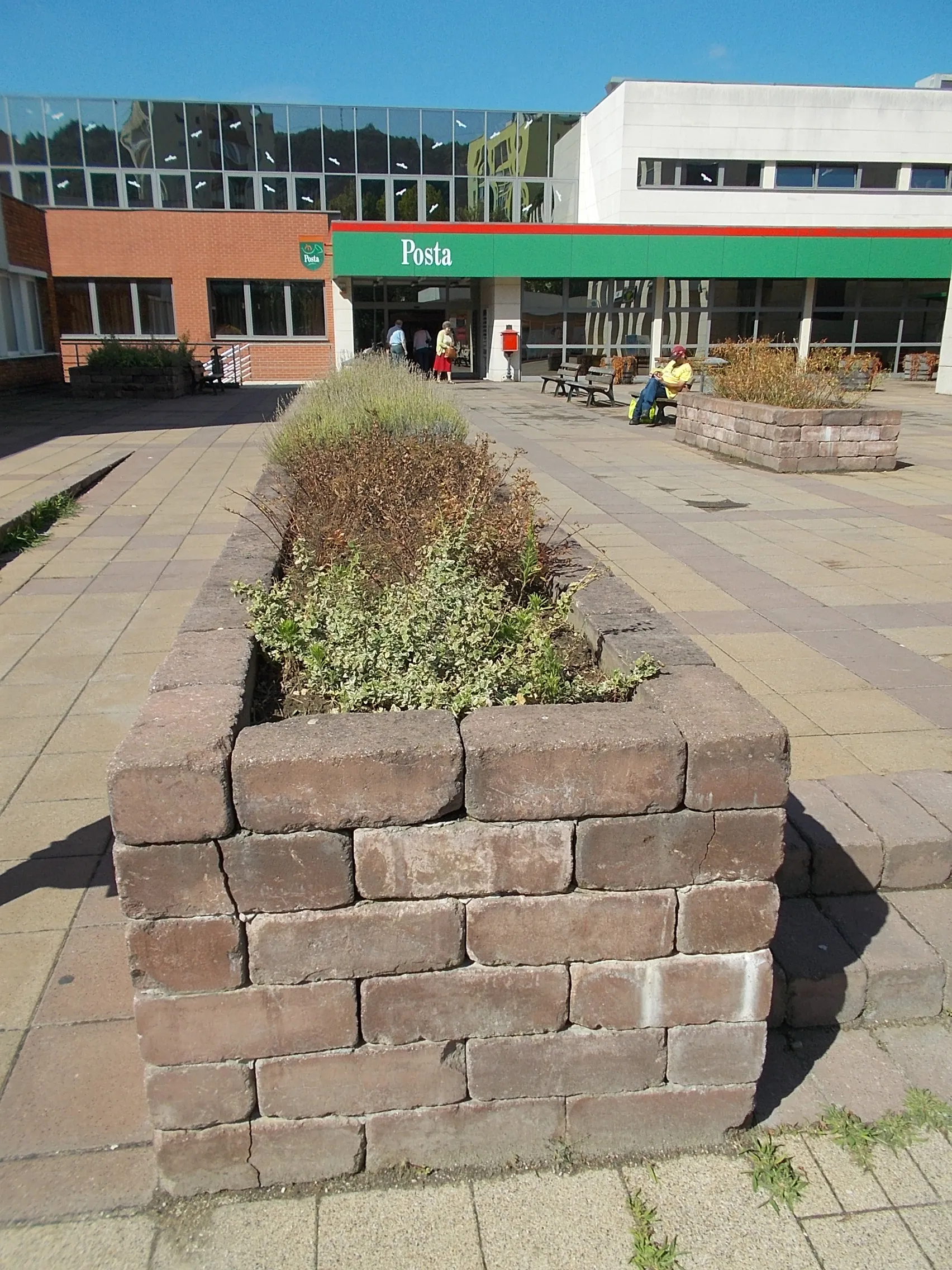 Photo showing: Brick-walled flower boxes before the post office. - Fő Square, Tatabánya, Komárom-Esztergom County, Hungary.