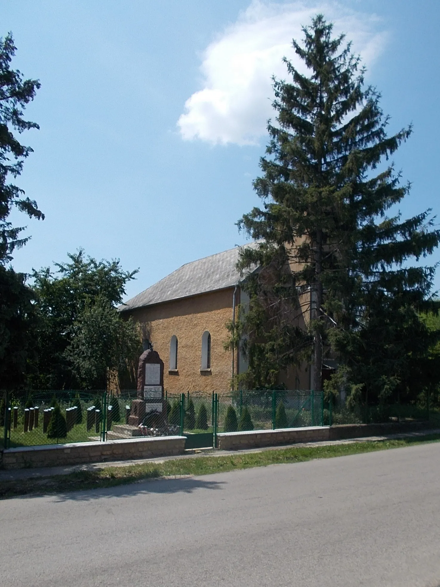 Photo showing: : R.C.  church (1957) War memorial (1930s red sandstone obelisk, with a WW2 plaque ? time, and a bronze turul statue on the top circa 2010?? ) - Padragiút (Road 7309), Csékút neighborhood, Ajka, Veszprém County, Hungary.