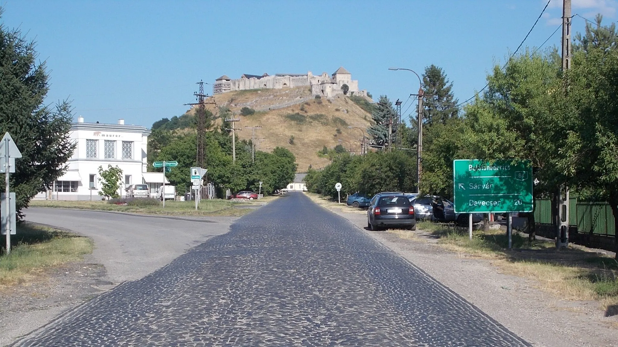 Photo showing: Sümeg has a unique "nature-given speciality", with a castle at the top of the regular cone-shaped nature protected hill in the center. Almost every part of the town offers a scenic panorama of the medieval fortification. It rises above the city at an altitude of 270 meters. Hill and Castle from Mihályfai Street, Sümeg, Veszprém County, Hungary.