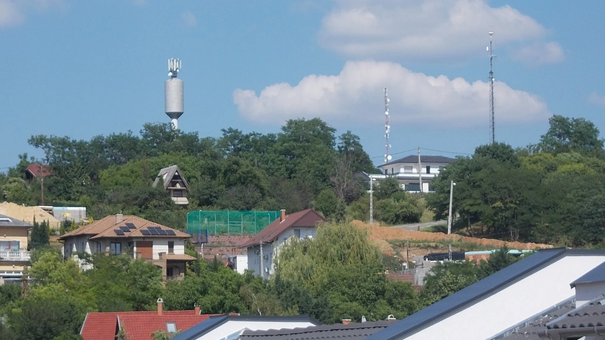 Photo showing: View toward hill with towers from Napsugár Street, Pécel, Pest County, Hungary.