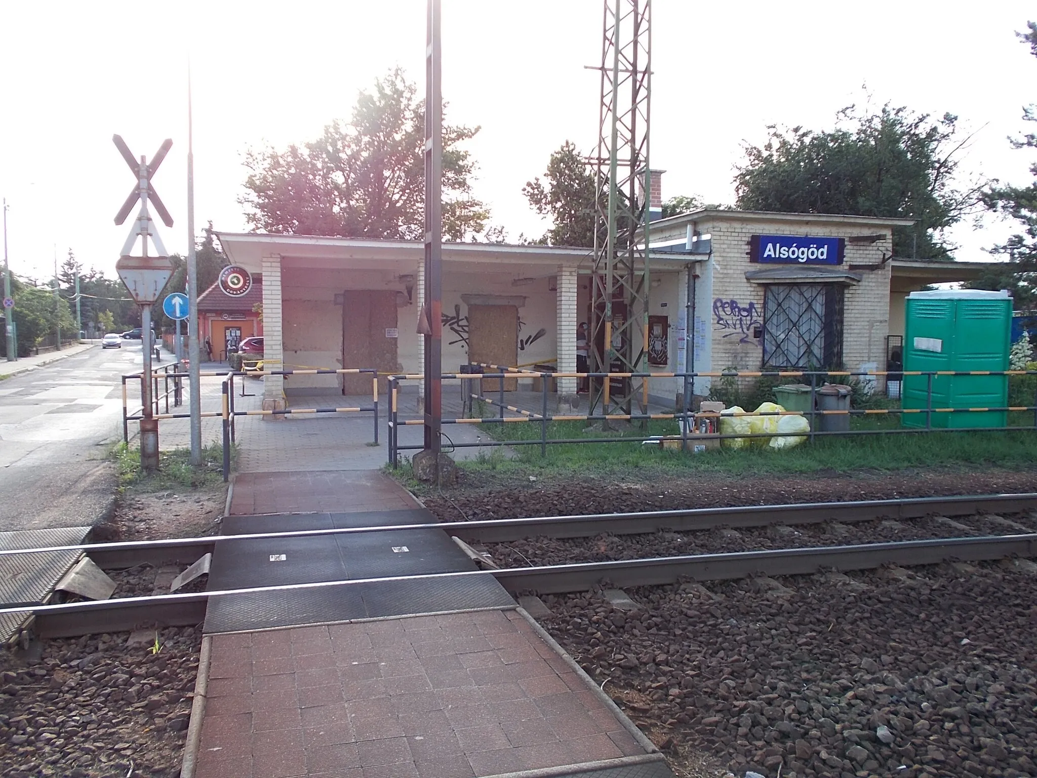 Photo showing: : Alsógöd train stop, level crossig, station building, mobile toilet  - Béke Road, Alsógöd neighborhood, Göd, Pest County, Hungary.