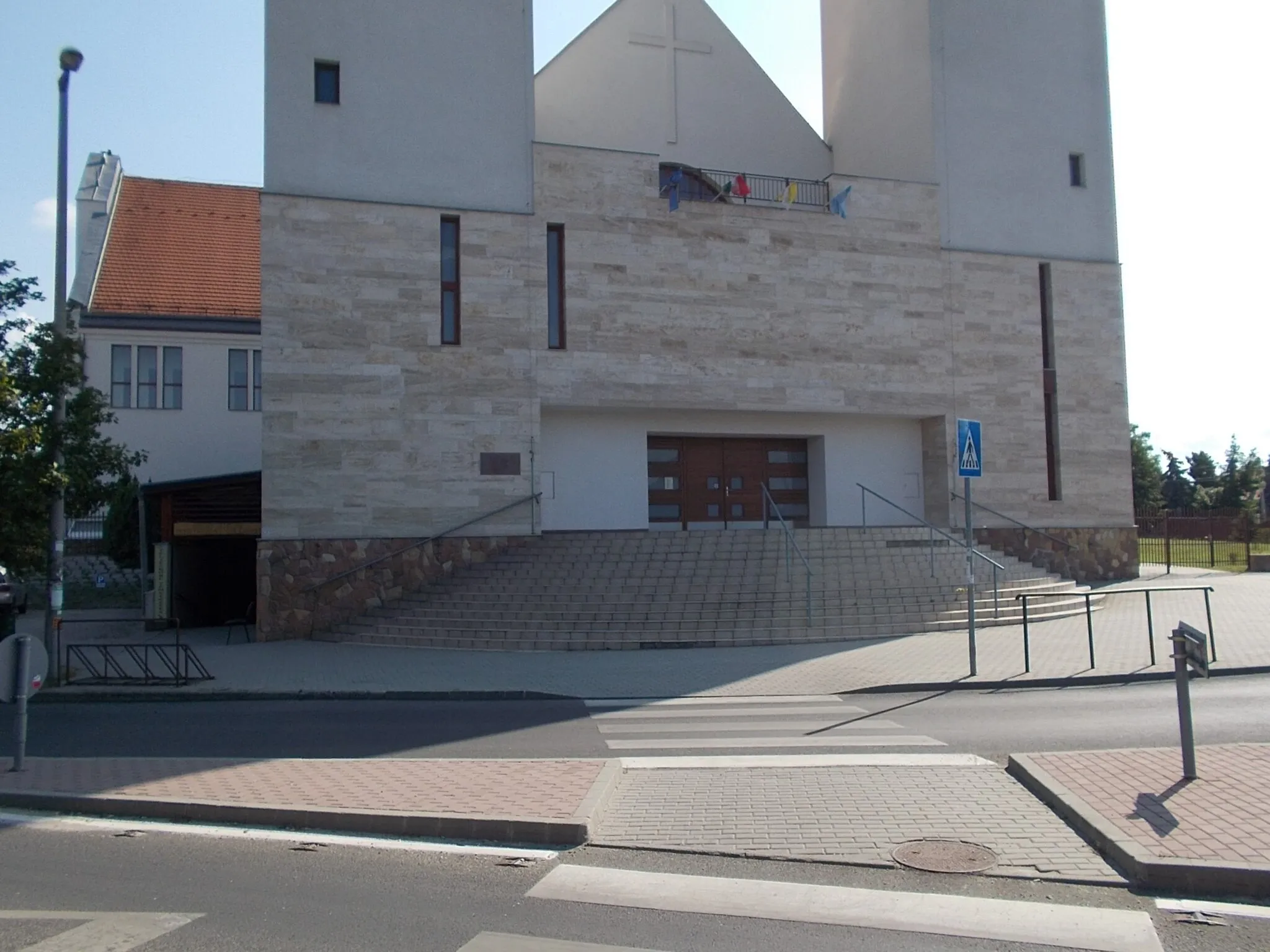 Photo showing: : Saint Nicholas church. Planned by Imre Trummer in 1996; foundation stone in 1998; church foundation completed in 2001-2002, All Saints Chapel completed in 2003, church nave and gallery/choir completed in 2006-2007.  The church's community hall and sacristy were completed 2008. The two 44-meter high towers in 2013. - Szent Erzsébet tér and Bajcsy-Zsilinszky utca corner, Szigetszentmiklós, Pest County, Hungary.
