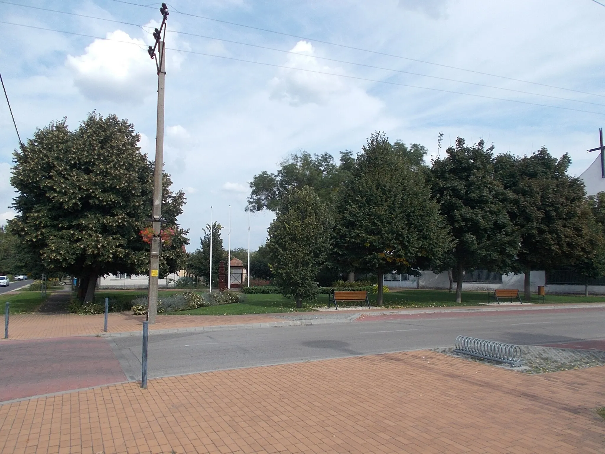 Photo showing: Park At back the kopjafa memorial (installed in 1990, unkonown artist) Refer to Hungarian Revolution of 1956, Hungarian Revolution of 1848, Romanian Revolution of 1989  - in a Park at Szent István Street and Somogyi Béla Street intersection, /Szent István Square other name Templom Square/, Gyálliget neighborhood, Gyál, Pest County, Hungary.