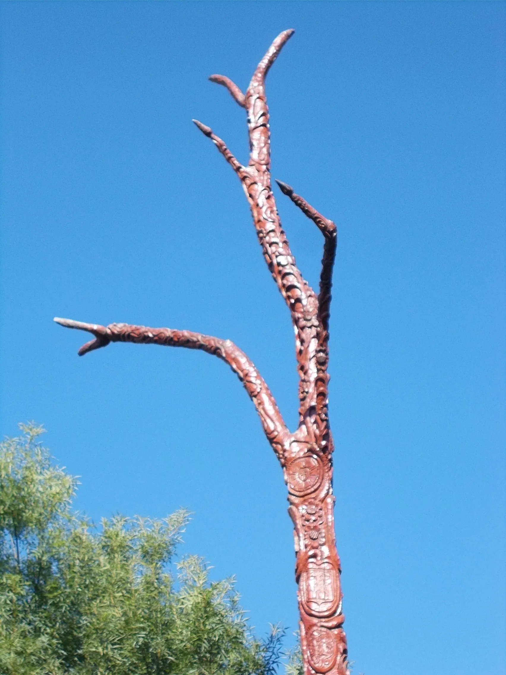 Photo showing: Tree of life by István Bognár woodcarver  (installed 2012)  /Tree of life in art, sculpture/ inscriptions on its:, rovas script, " Made by Loving Citizens of Üllő2010 2011." Dandelion Member Kindergarten"" "Sunflower Member Kindergarten" "Lily of the Valley Member Kindergarten" - in a small Park at Ócsai Road andPesti Road (Highway 4) corner, Üllő, Pest County, Hungary.