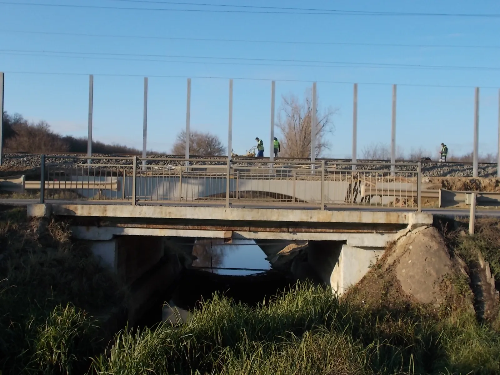 Photo showing: : Road and railway bridges over the Rákos stream. Budapest–Hatvan railway line noise protection wall under reconstuction - close to Rákóczi utca (Route 3102 and Route 3103), Isaszeg, Pest County, Hungary.