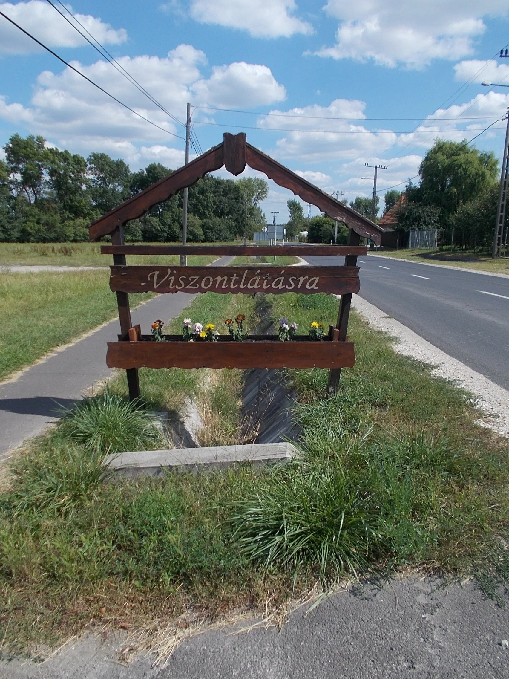 Photo showing: : Farewell sign and flower planter(s) - Pesti Road (Main road 4), Irsa neighborhood, Albertirsa, Pest County, Hungary.