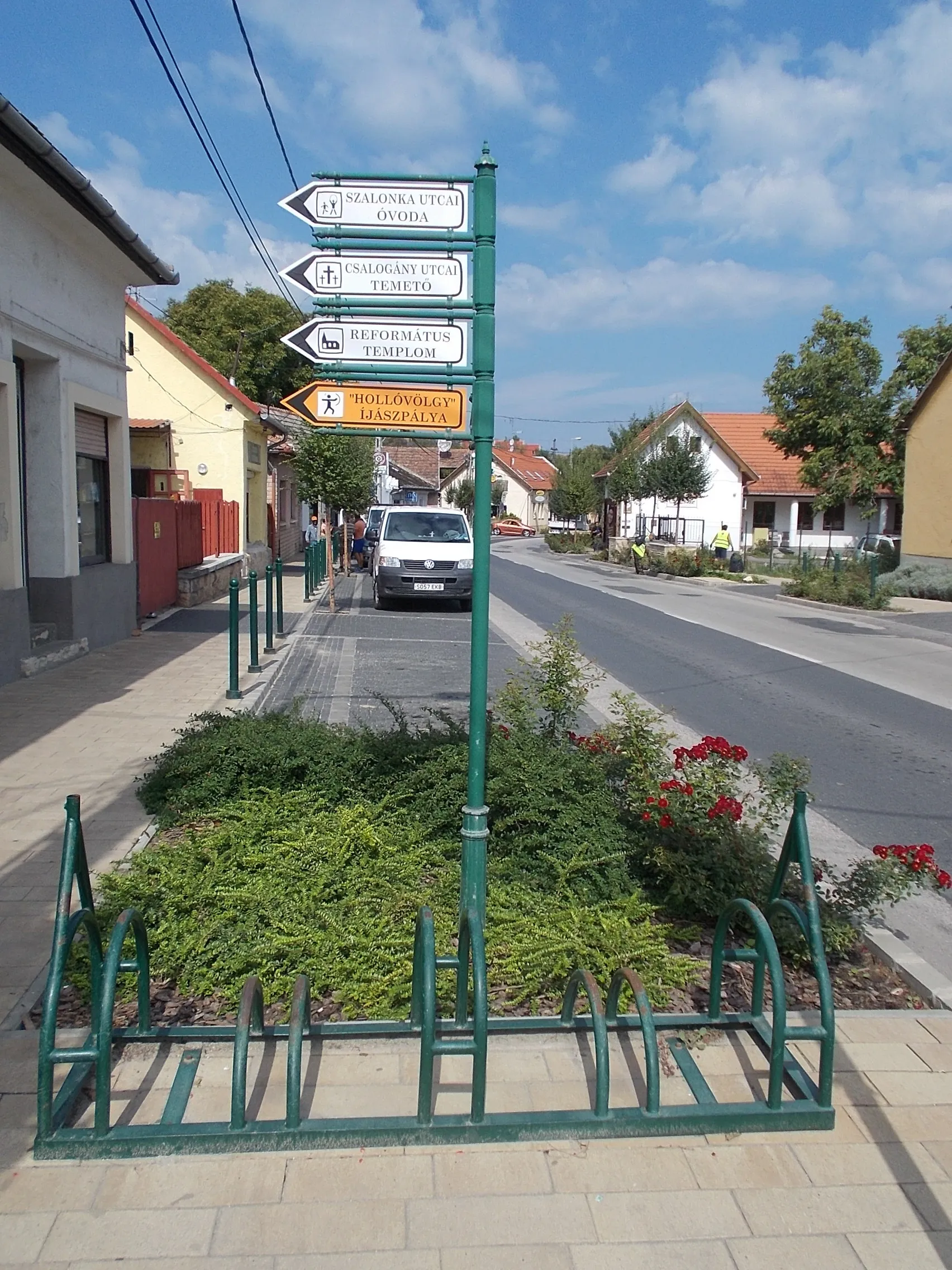 Photo showing: Fingerpost, bicycle racks - Budai Road (Road 1115) and Petőfi Platz, Budakalász, Pest County, Hungary.
