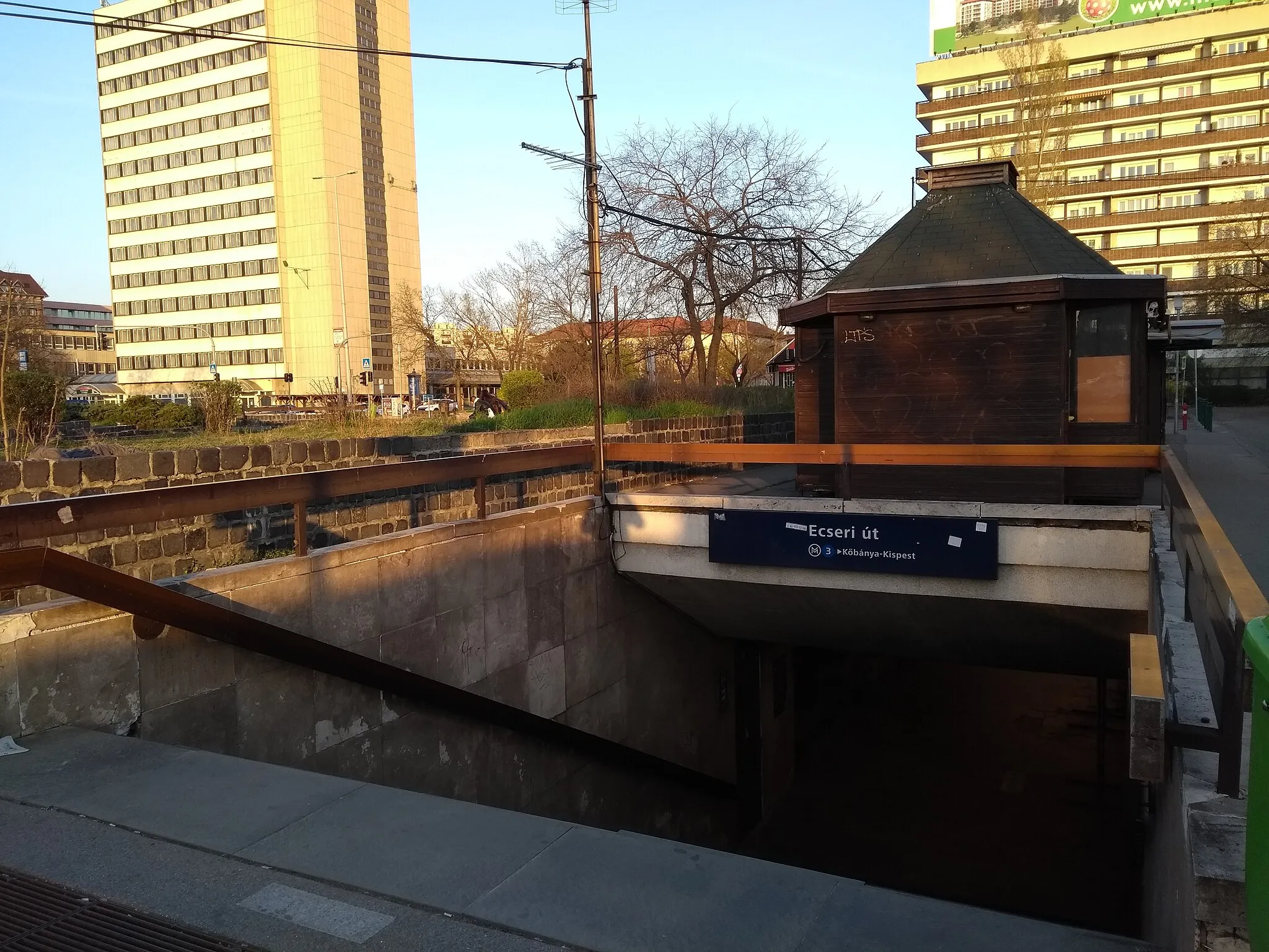 Photo showing: Ecseri út metro station to Kőbánya-Kispest in Budapest, enterence to the platform to Kőbánya-Kispest, overground. Shortly before the section was closed because of renovation on April 6th. You can see Post office 100 across Üllői út.