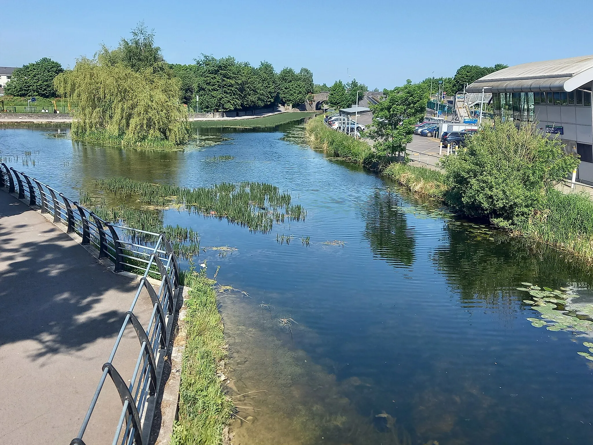 Photo showing: Looking east from a footbridge over the Royal Canal, Dublin. To the left, the basin of Maynooth dock or harbour. May 2023.
