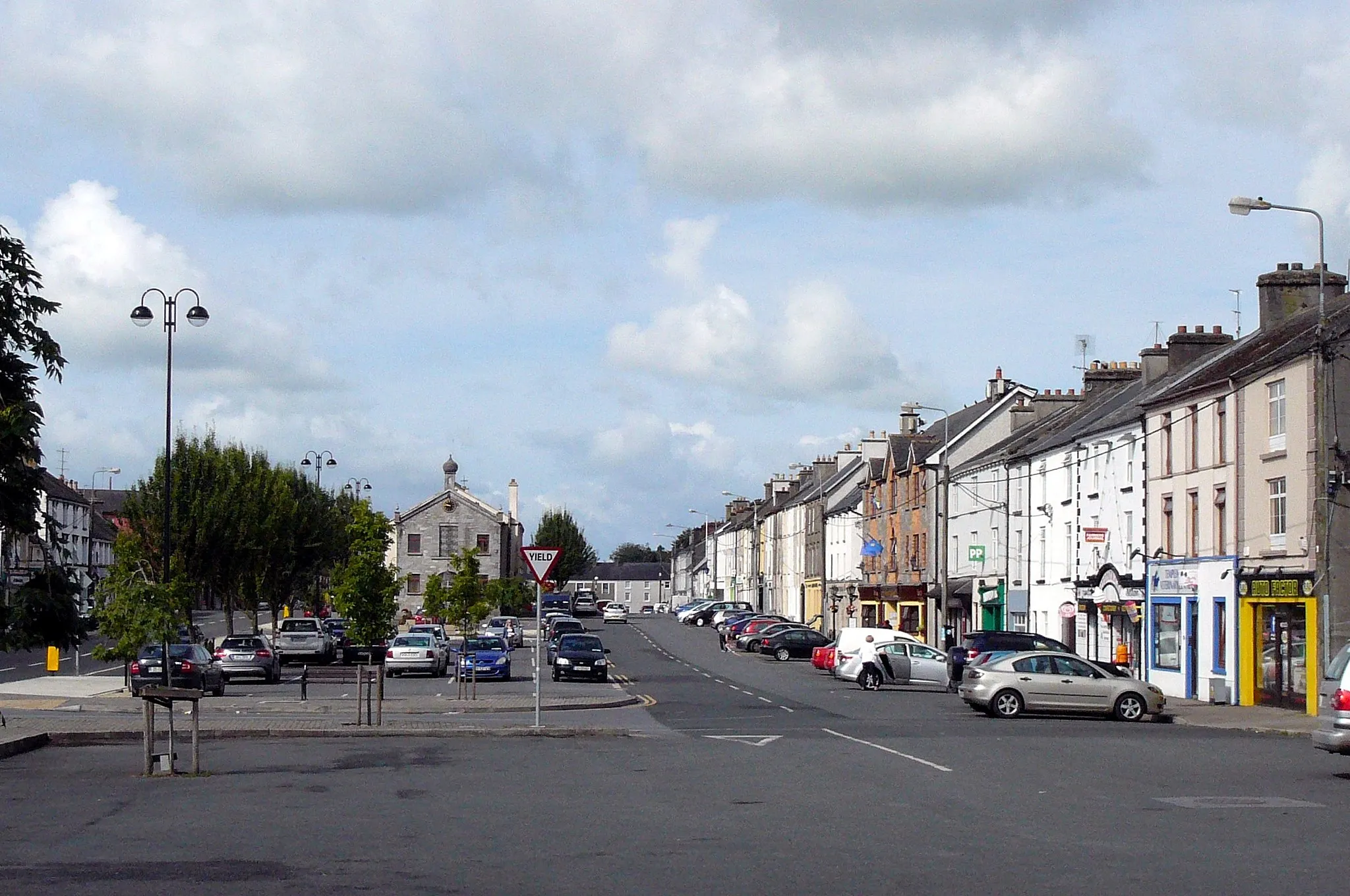 Photo showing: View of Main Street, Templemore, Co Tipperary, Ireland with Town Hall in the background. Image shows the residential south-west side of the main street, traffic running on a parallel street to the left.