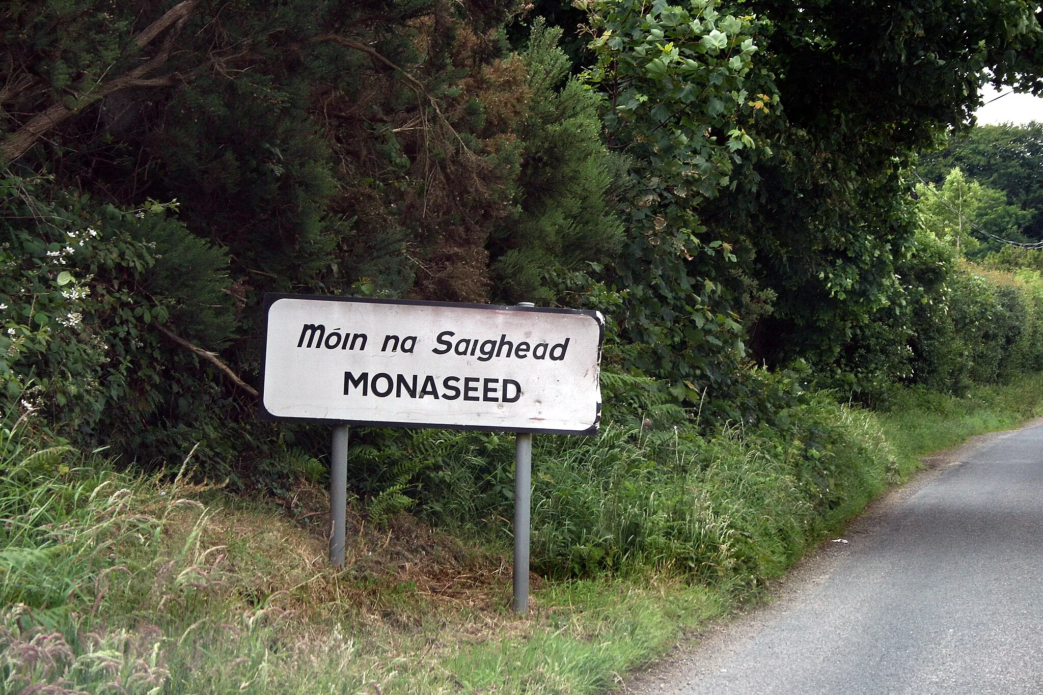 Photo showing: Announcing the village of Monaseed, County Wexford, Ireland. It's a long walk from this sign to the actual village!