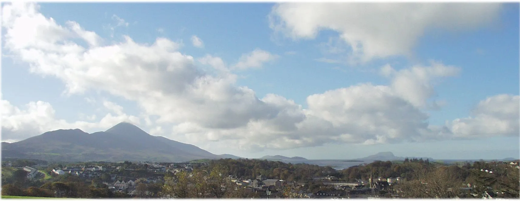 Photo showing: A panoramic view of Westport as seen from the Castlebar side, showing Croagh Patrick (left background) and Clare Island (right background)