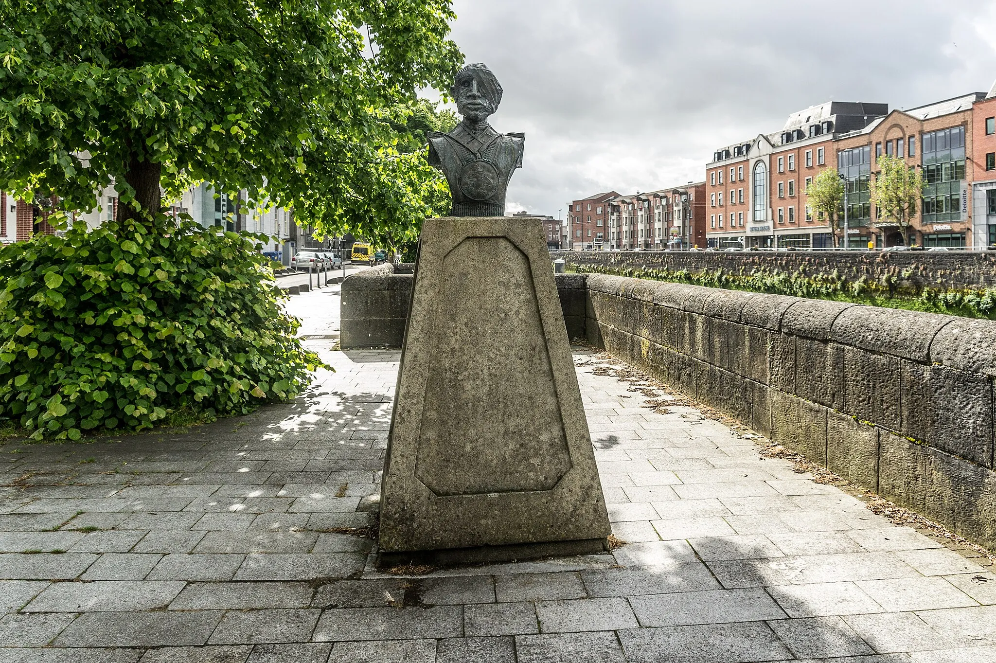 Photo showing: My understanding is that George’s Quay is named after King George III and across the river is Charlotte’s Quay which is named after his wife. According to a tourist guide that I overheard the Abbey river that flows along the quay separated the two. After hearing what the guide had said I decided to check Wikipedia and came across the following “On 8 September 1761 in the Chapel Royal, St James's Palace, the King married Princess Charlotte of Mecklenburg-Strelitz, whom he met on their wedding day. A fortnight later, both were crowned at Westminster Abbey. George remarkably never took a mistress (in contrast with his grandfather and his sons), and the couple enjoyed a genuinely happy marriage.” As they say in Ireland, never let the facts get in the way of a good story.

The Anti-war memorial is located in Limerick City. Located on George's Quay in the city center the two piece sculpture represents the two sides of war. Created by Vincent Browne in 1987 the sculpture consists of two busts, one of a tyrannical powerful figure appearing tall and strong, the other of an unknown injured soldier, a victim of war. The sculptures stand on ten foot tall plinths facing one another on the Quay. The sculpture was a public commission and the hope was that the addition of this piece would promote public sculpture in Limerick. Four other pieces were also created at the same time by artists Tom Fitzgerald, Eileen McDonagh, Jim Flavin and Tracy McKenna. These pieces are located at the Potato Market and the Customs House, now the Hunt Museum. These sculptures were created as part of the Cultural Agreement signed between the Arts Council and Limerick Corporation. This was the first partnership between the Arts Council and a local council.