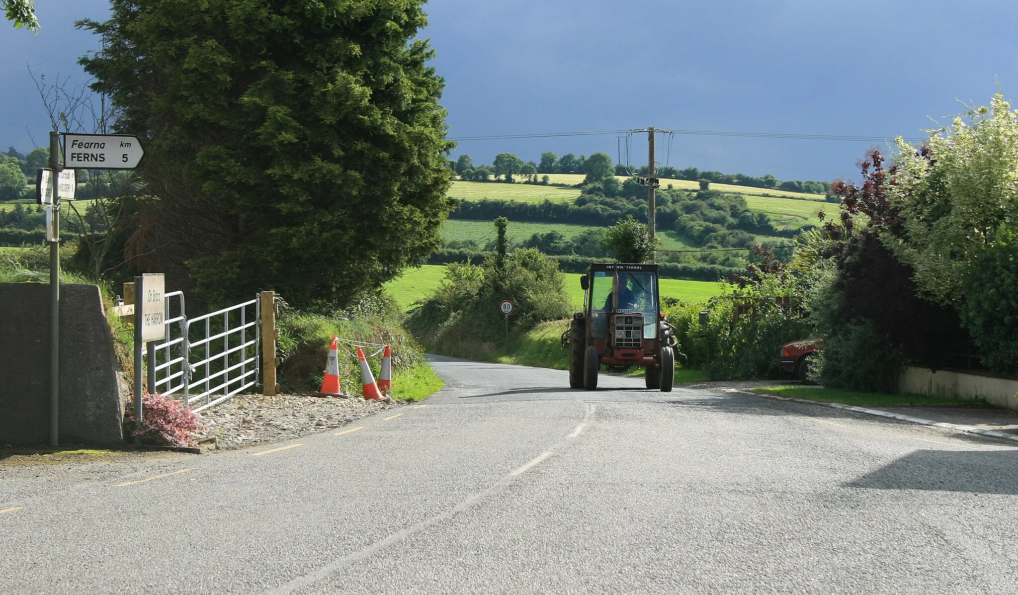 Photo showing: IHC Tractor approaching the hamlet of The Harrow, near to Myaugh, Glen Village, Boleyvogue and Tinnacross Cross Roads, County Wexford, Ireland.