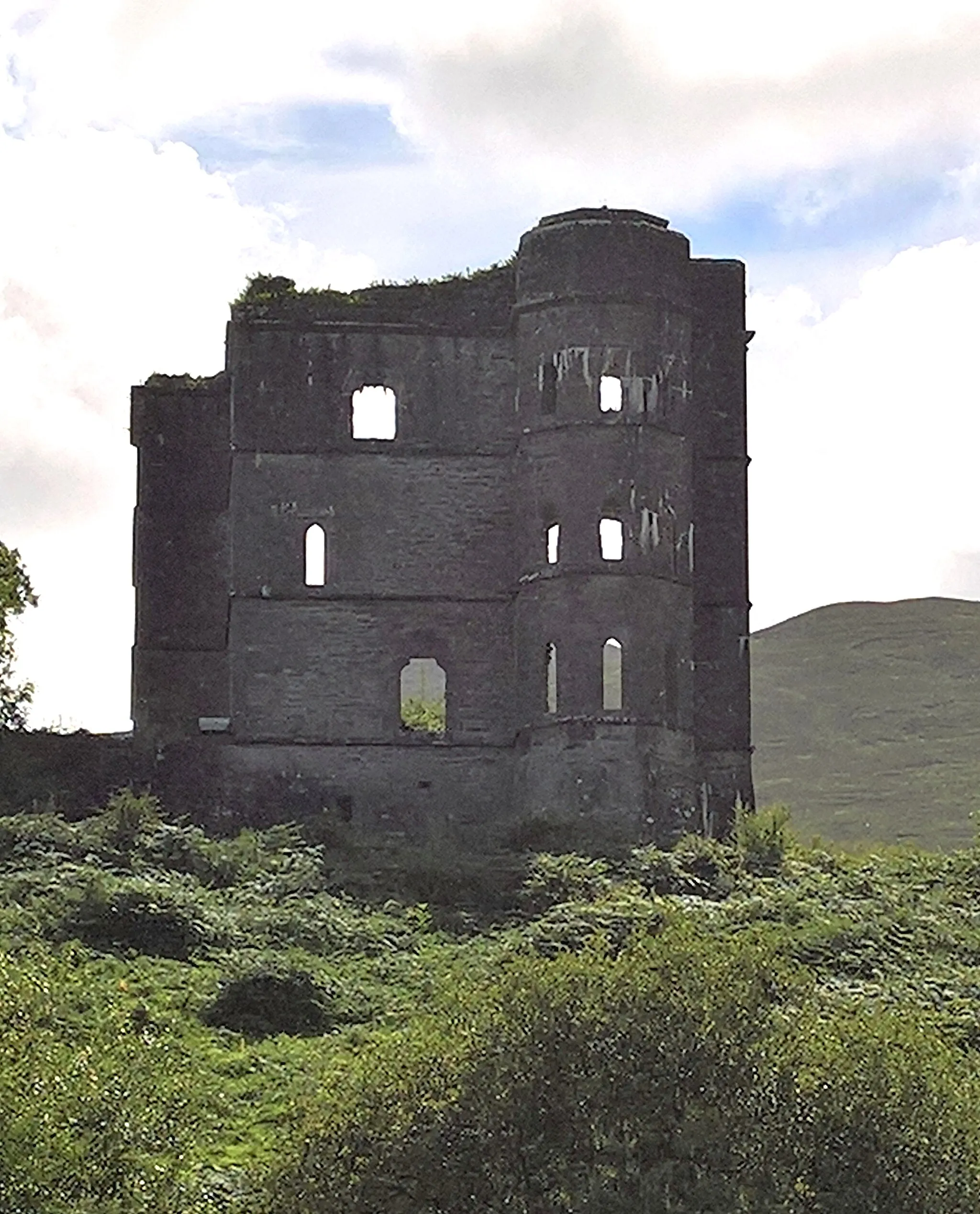 Photo showing: Wynn's Castle (auch Wynne's Folly, Headley Towers oder Glenbeigh Towers Castle) sind die Ruinen eines burgähnlichen Schlosses für Lord Headley Wynn(e) südlich des Ortes Glenbeigh und östlich der Bundesstraße N70 (Ring of Kerry), auf der Iveragh Halbinsel (Uíbh Ráthach) in der Gälischen Region (Irisch sprechend) des County Kerry in Irland. Blick nach Osten, N70 zur Schlossruine