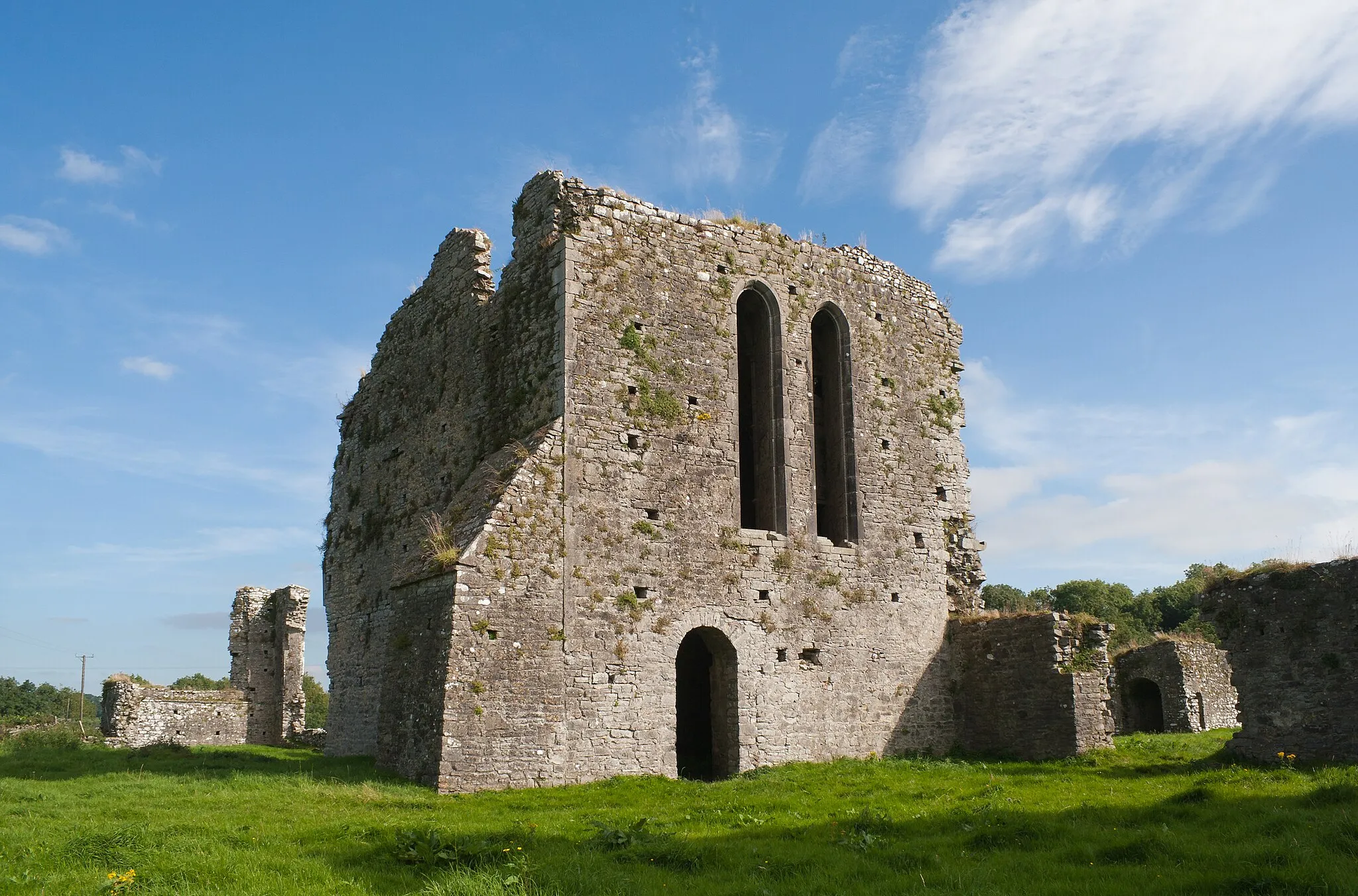 Photo showing: North-west view of the church and the belfry tower. At the left the remaining ruins of the east wall of the choir are to be seen. Most of the intermediate walls, north and south of the church, are not preserved.