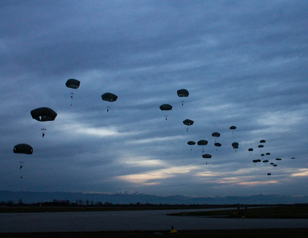 Photo showing: Paratroopers from the 2nd Battalion, 503rd Infantry Regiment, 173rd Airborne Brigade conduct a jump at dusk here Dec. 10, 2014, during an airfield seizure. The battalion conducted airfield seizure training at Rivolto Italian Air Force Base to increase their readiness as the Army’s Contingency Response Force in Europe.  (U.S. Army Photo by 1st Lt. Angelina Cillo)