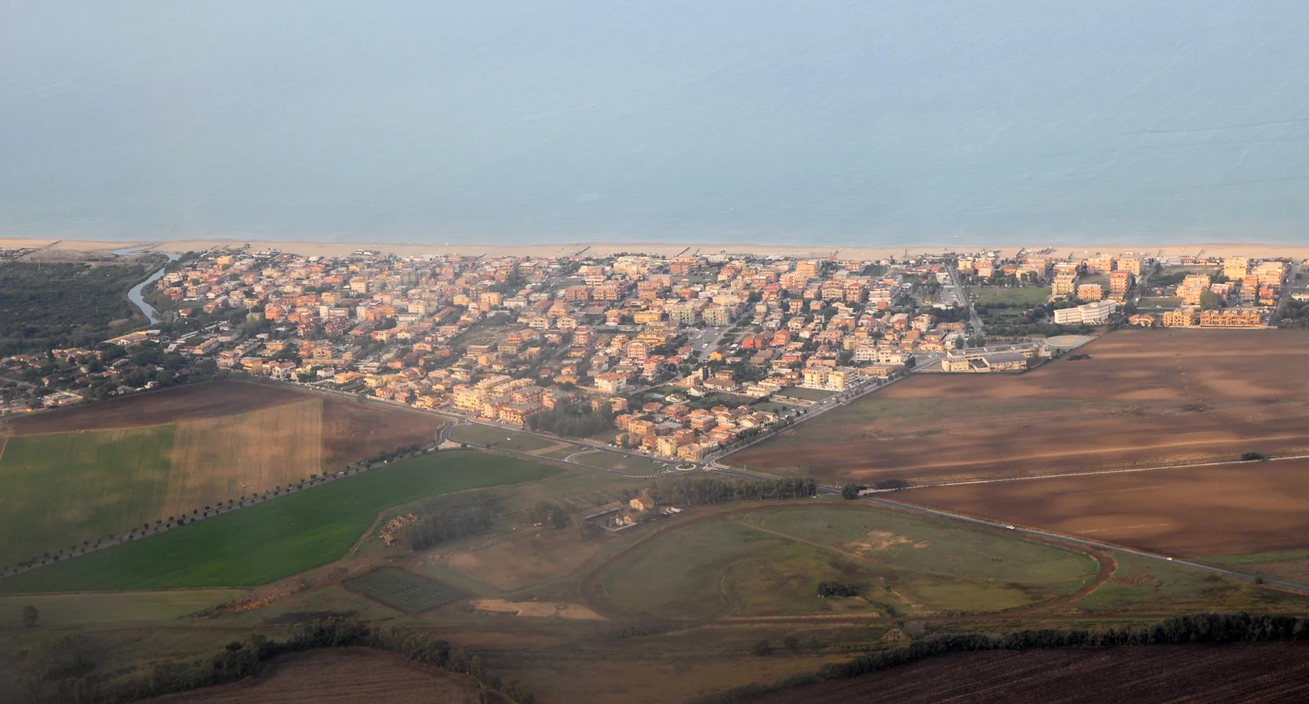 Photo showing: Aerial view of the coastal town of Passo Oscuro, located about 20 km west of Rome. The Tyrrhenian Sea is seen in the background.