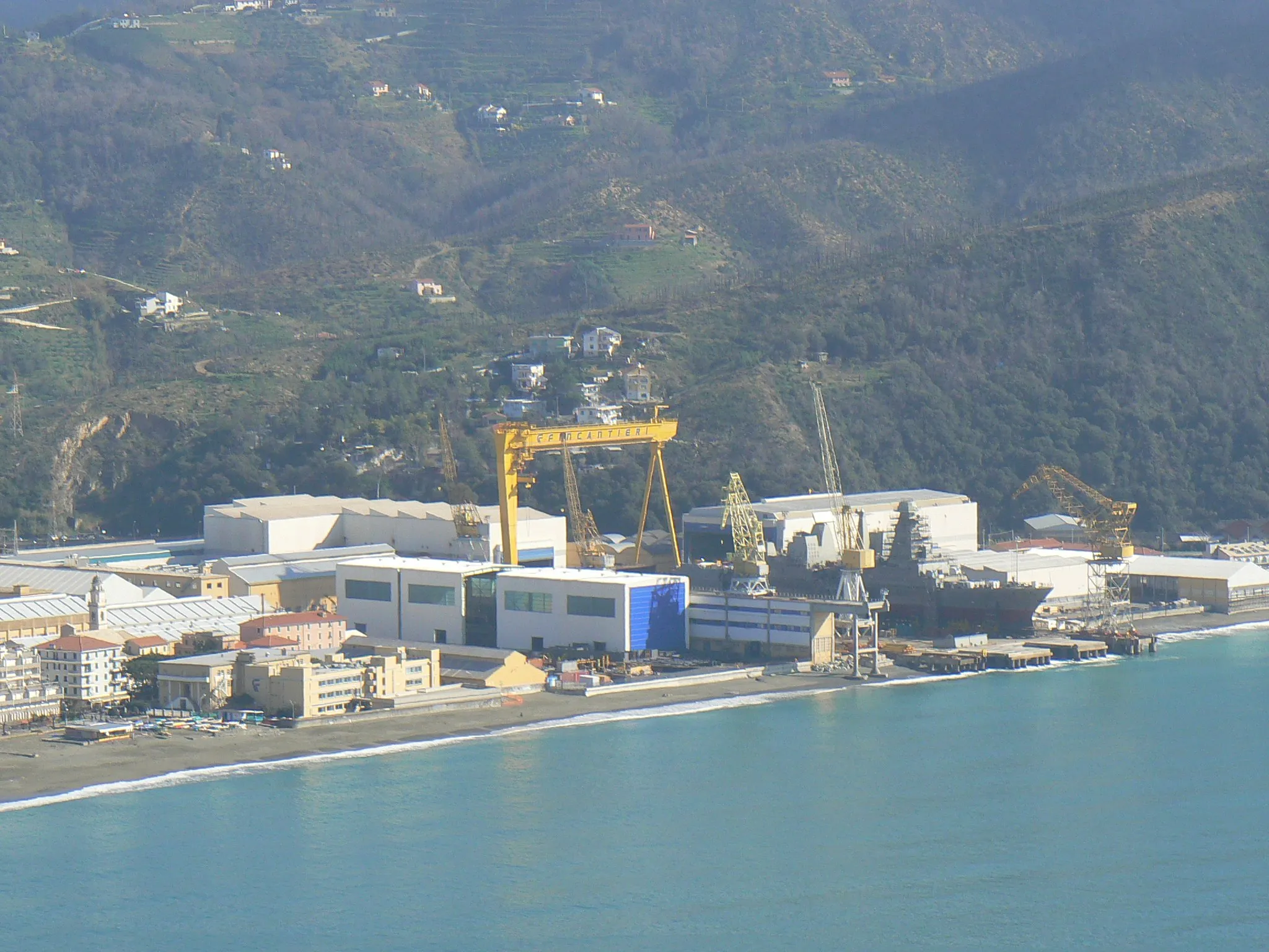 Photo showing: The shipyards of Riva Trigoso seen from Punta Manara. In the docks the Doria-class destroyer Caio Duilio nears completion, and will be launched on 23 October 2007