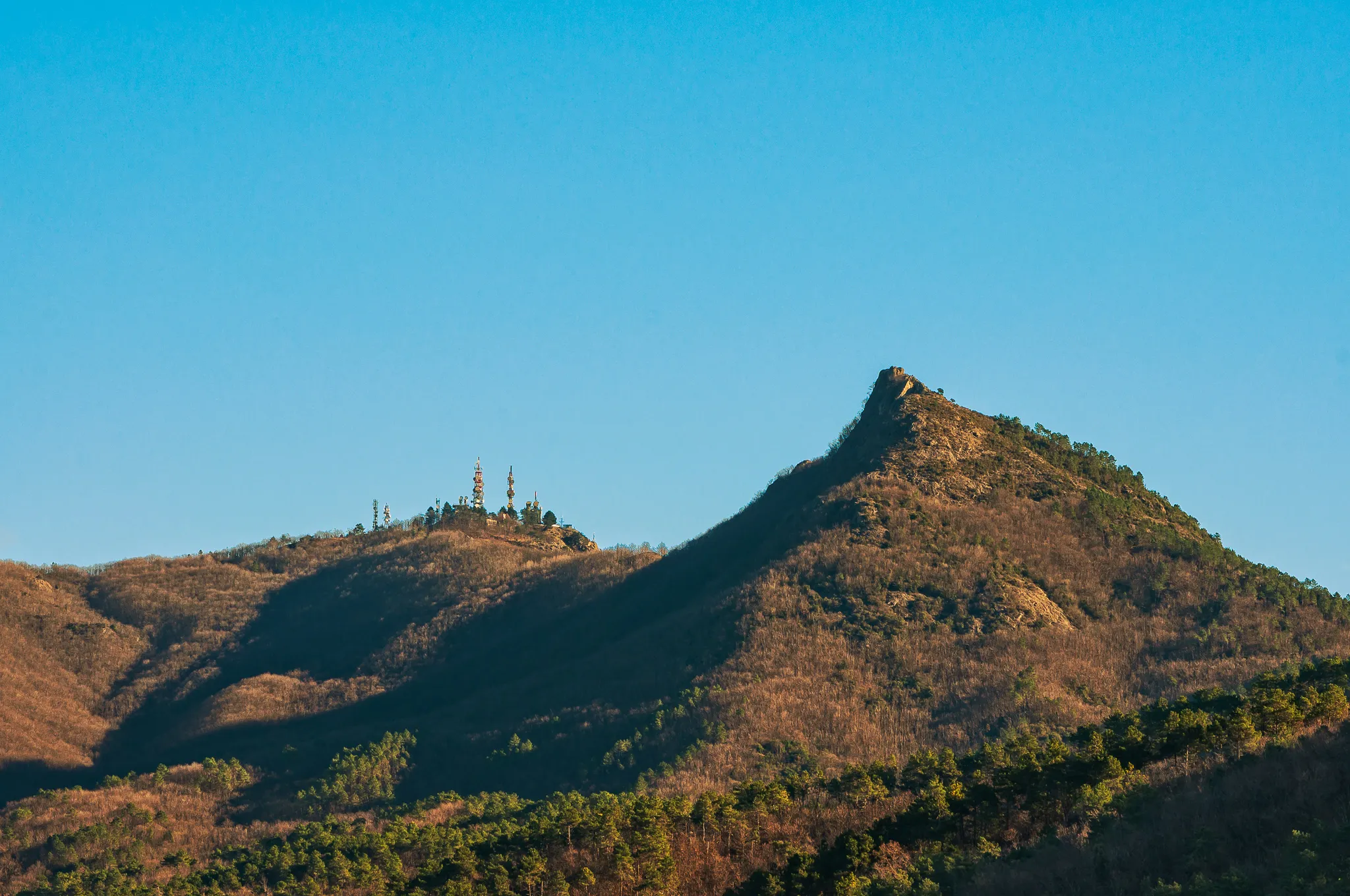Photo showing: In the foreground the summit of Mount Pietra di Vasca; in the background Mount San Nicolao, topped by communication devices.