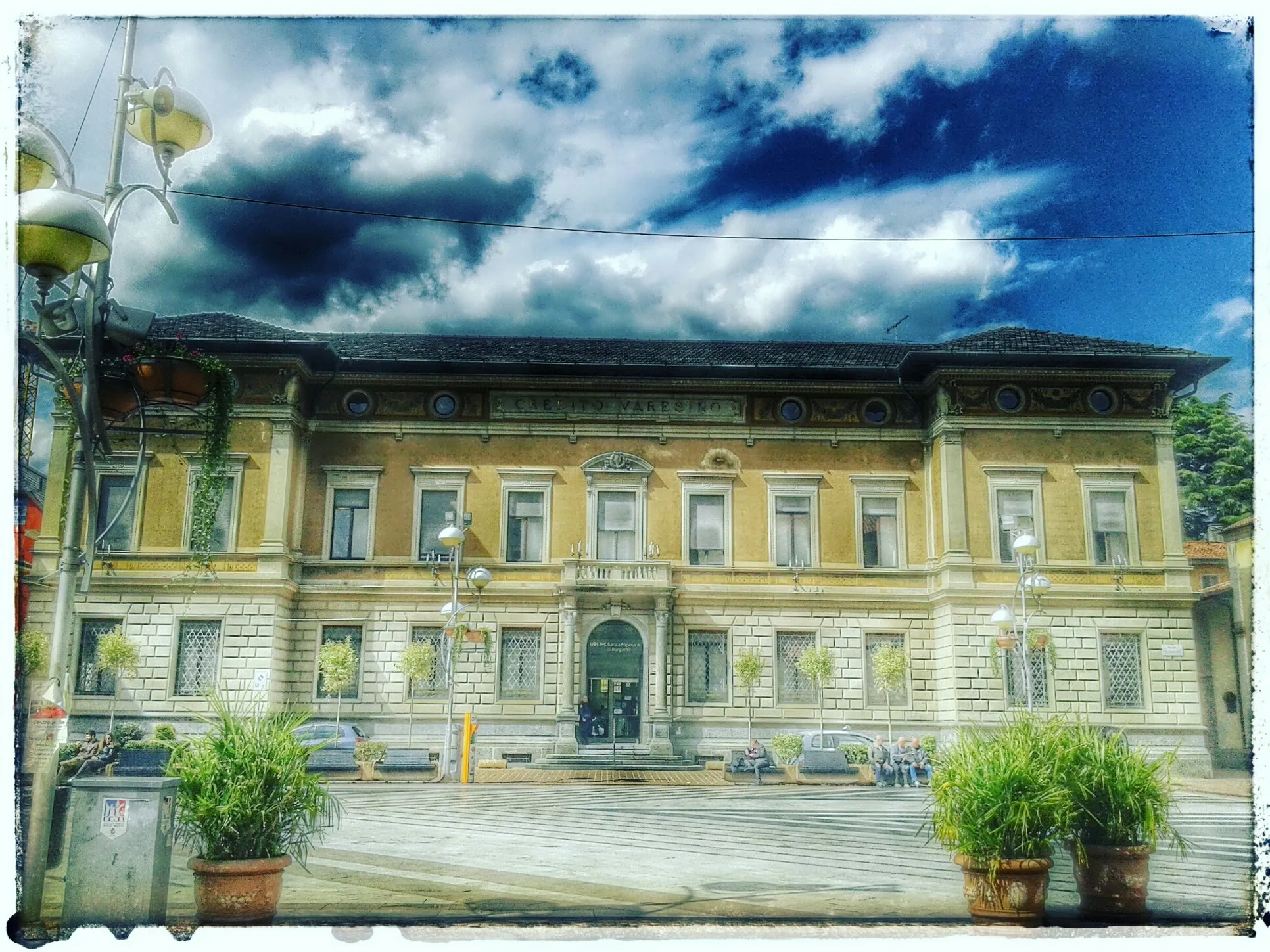 Photo showing: Piazza con banca che si slancia tra le nuvole.