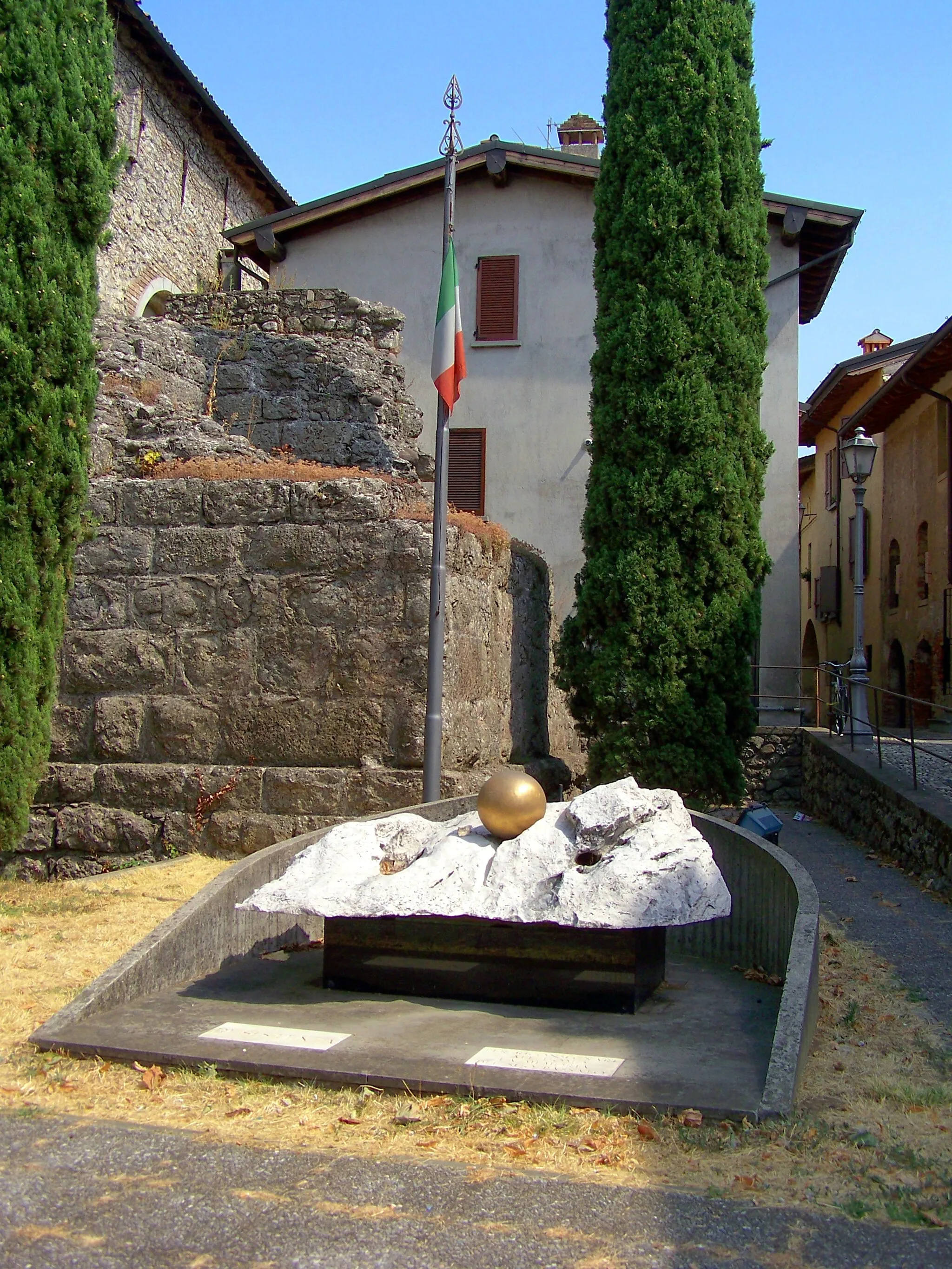 Photo showing: Il monumento ai caduti di Coccaglio. Dietro, sulla sinistra, la base della torre romana (I secolo a.C.)