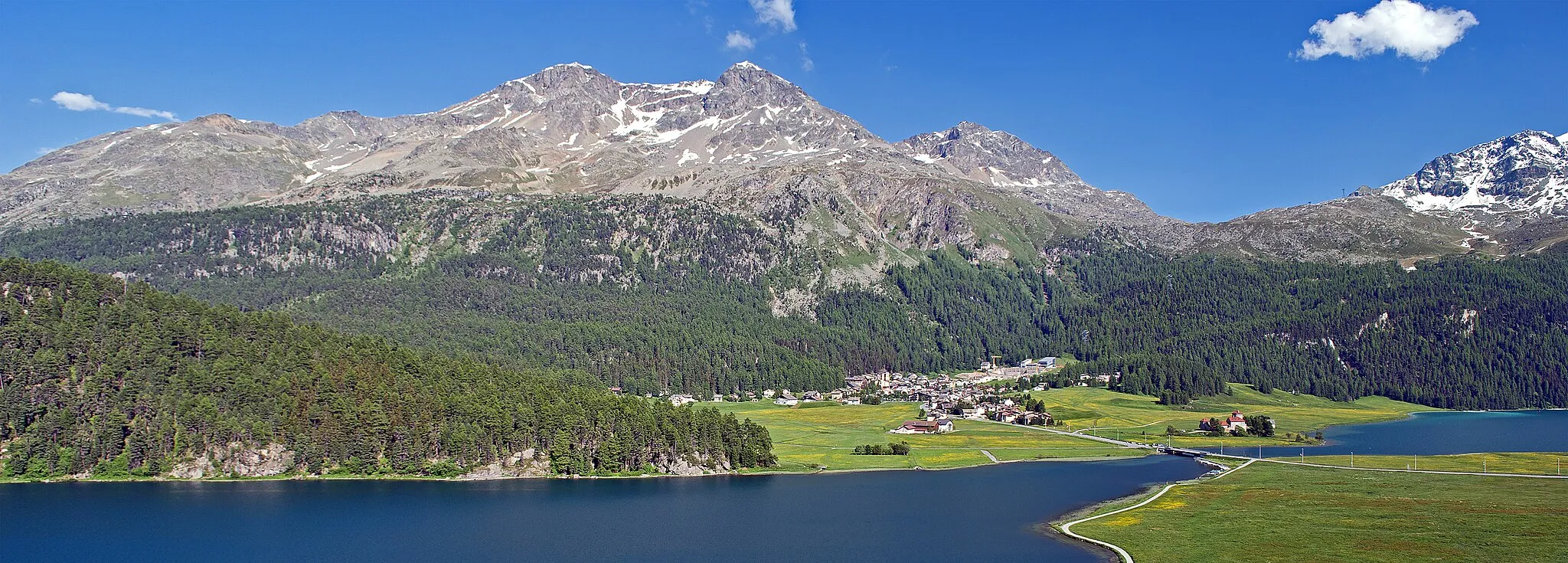 Photo showing: Silvaplana-Surlej, 1,815 metres (5,955 ft), is a hamlet of Silvaplana in Engadin/Switzerland. The image also shows the surrounding lakes Lej da Champfèr and Lej da Silvaplana and some of the nearby mountains from the Bernina range. The village contains the Corvatsch cablecar bottom station.