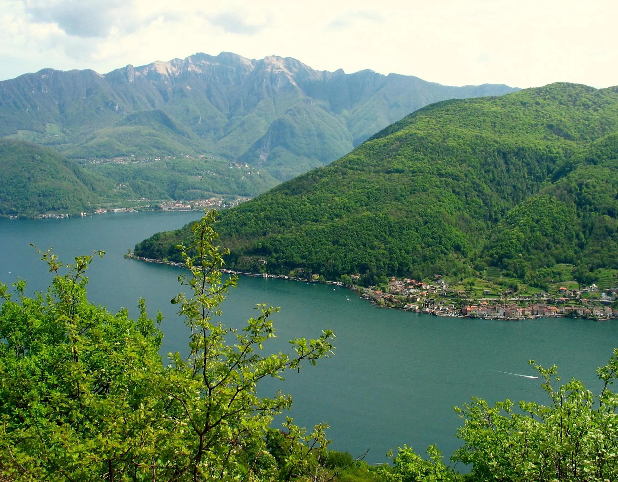 Photo showing: Lake Lugano seen from above Morcote (Ticino). In the middle: the village of Brusino Arsizio and the Monte San Giorgio. In the background: Monte Generoso.