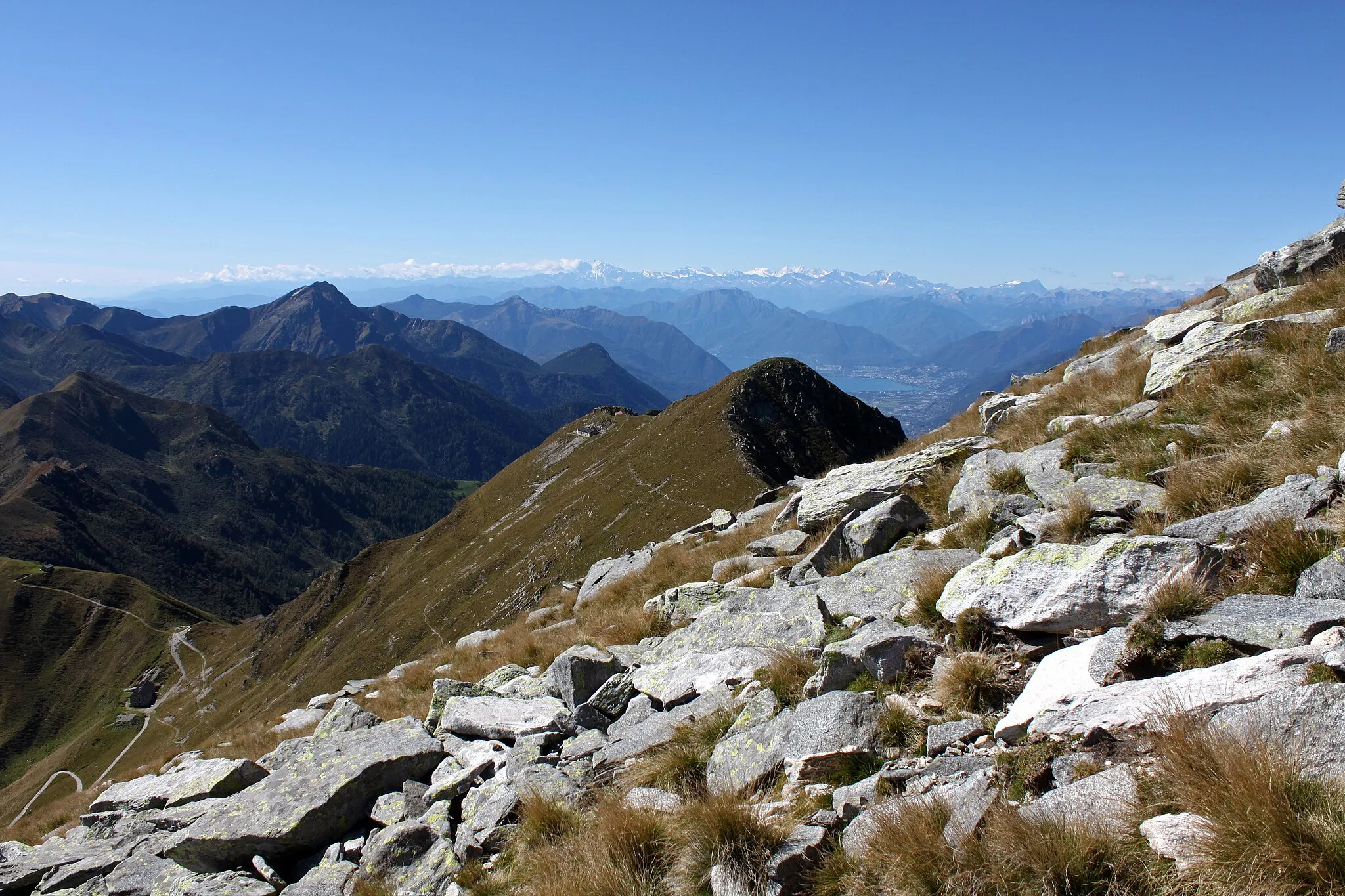 Photo showing: An der Südflanke geht es Aufwärts zum Monte Marmontana ( 2316 m.ü.M.). Der Berg liegt genau im Grenzbereich zwischen der Schweiz und Italien. In der Bildmitte liegt der Cima di Cugn (2180 m.ü.M.) mit dem gleichnamigen Rifugio. Links unten ist der Passo San Jorio (2010 m.ü.M.), Grenzpunkt zwischen Italien und der Schweiz. In der Ferne ist der Lago Maggiore zu sehen.