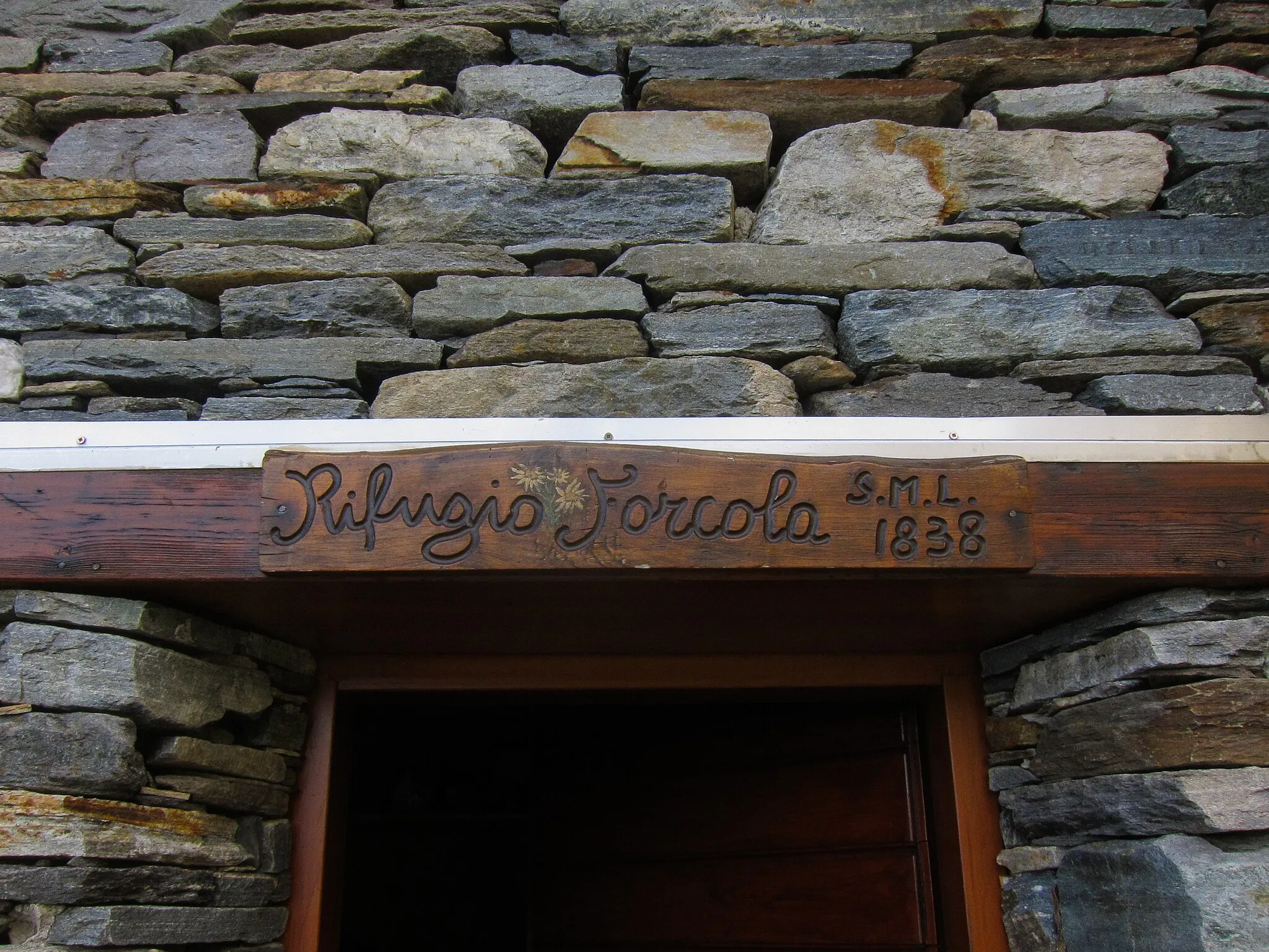 Photo showing: The door lintel of the bivouac "Rifugio Forcola" in Valchiavenna, province of Sondrio, region Lombardy in Italy. The picture was taken on the 12th of october 2019. 12-10-2019