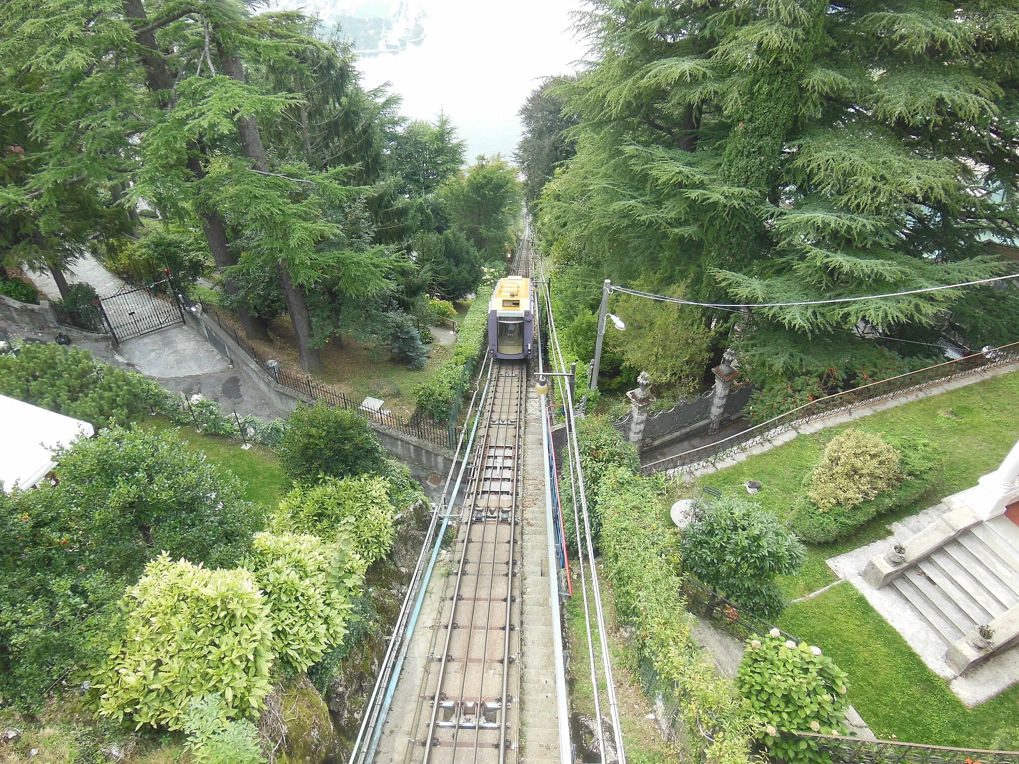 Photo showing: Looking down the line of the Como–Brunate funicular, from a road bridge just below the upper station. One of the cars is descending. For more information, see the wikipedia article Como–Brunate funicular.