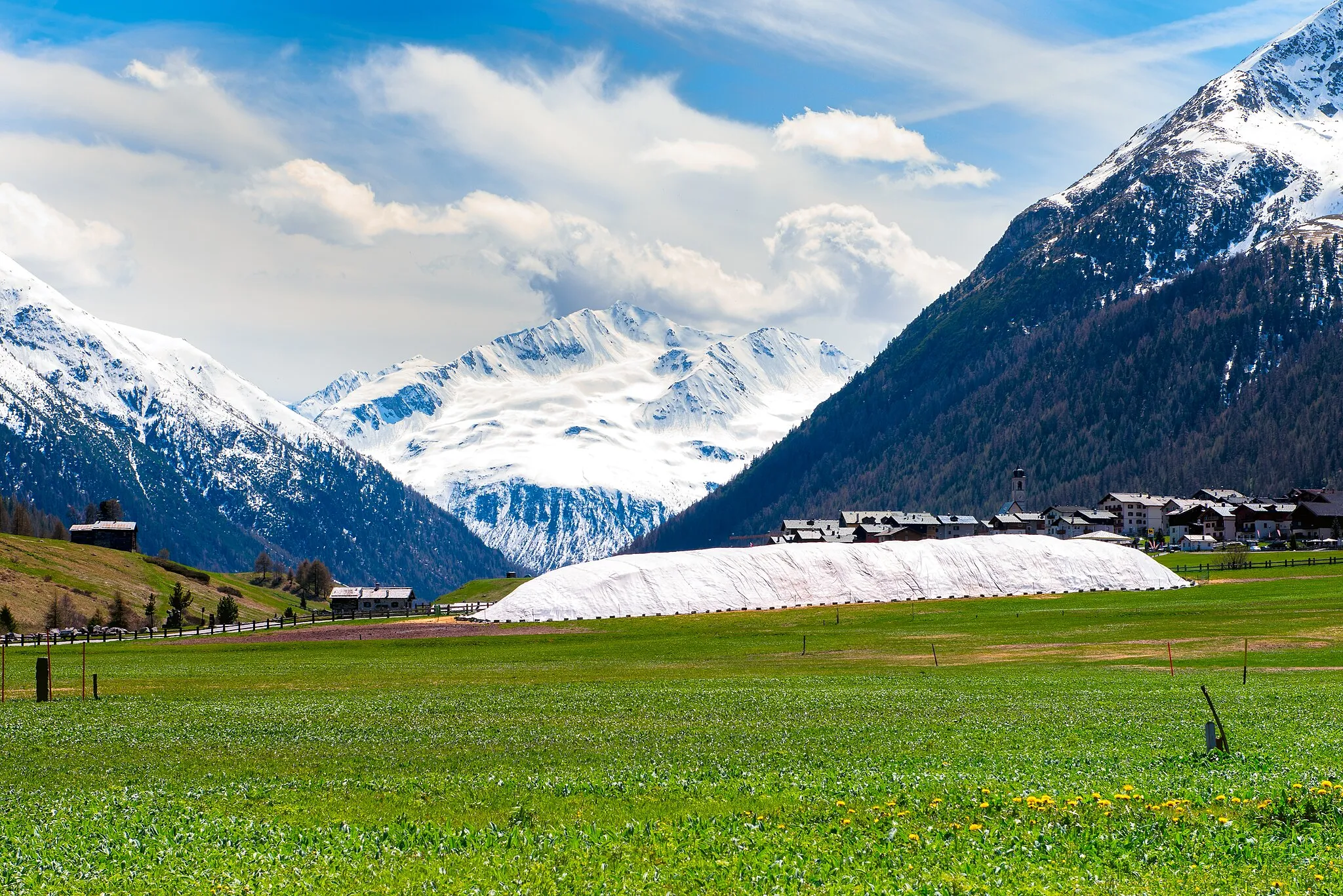 Photo showing: The snow conserved with the snowfarm technique in Livigno, is used for two things: first one for a summer cross-country skiing race on real snow, called "Palio delle Contrade", where the inhabitants of Livigno race for the title of "Best district of Livigno". Secondly the snow is used in october, for an early opening of the cross-country track, to allow athletes coming from all over the world to practice altitude training before the World Cup races and Olympic games.