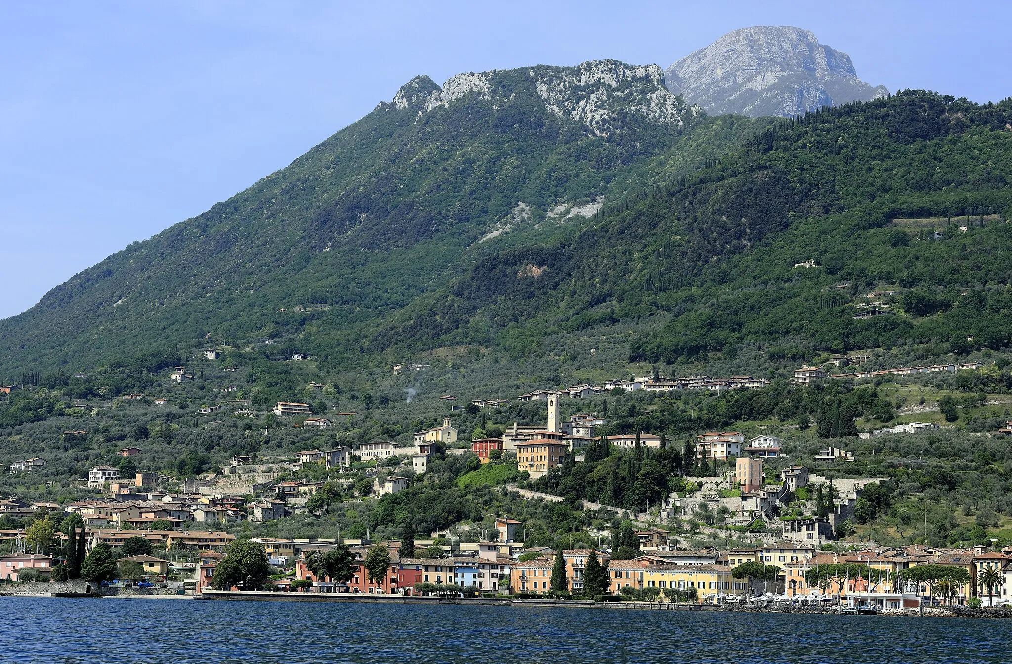 Photo showing: Vom Kursschiff Riva–Peschiera steuerbord querab, hinter dem Bergrücken liegt das Valle delle Cartiere; das aus ihm abgetragene Material bildet den Schüttkegel, auf dem Toscolano Maderno liegt. Der Monte Pizzocolo dahinter ist weit nach Süden vorgeschoben und damit über dem Südteil des Gardasees sehr dominant.