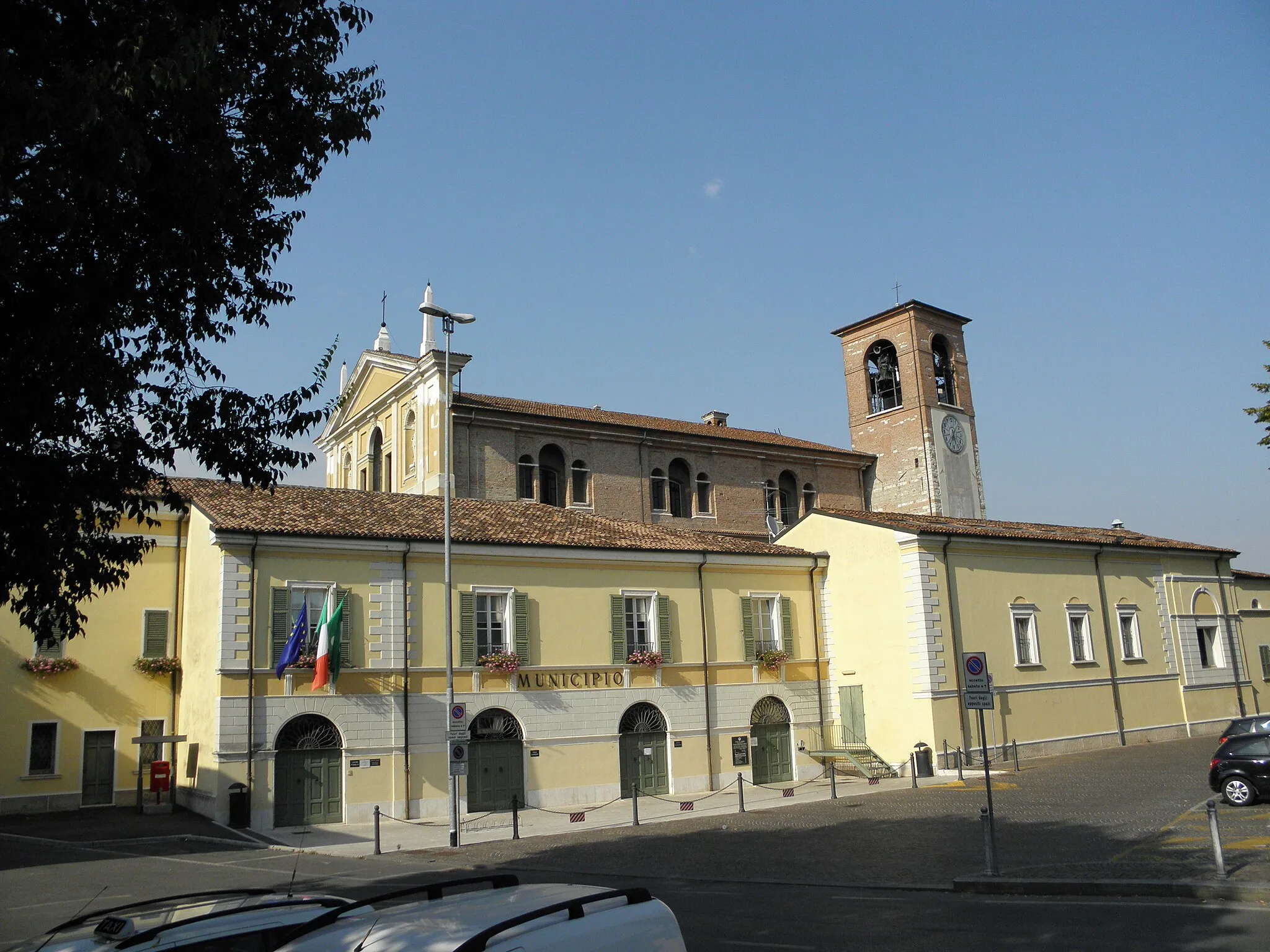 Photo showing: Ghedi, Palazzo Comunale: prospetto su Largo Zanardelli. In secondo piano dietro il tetto spunta la Chiesa parrocchiale di Santa Maria Assunta (XVII secolo) con il precedente campanile del XV secolo.