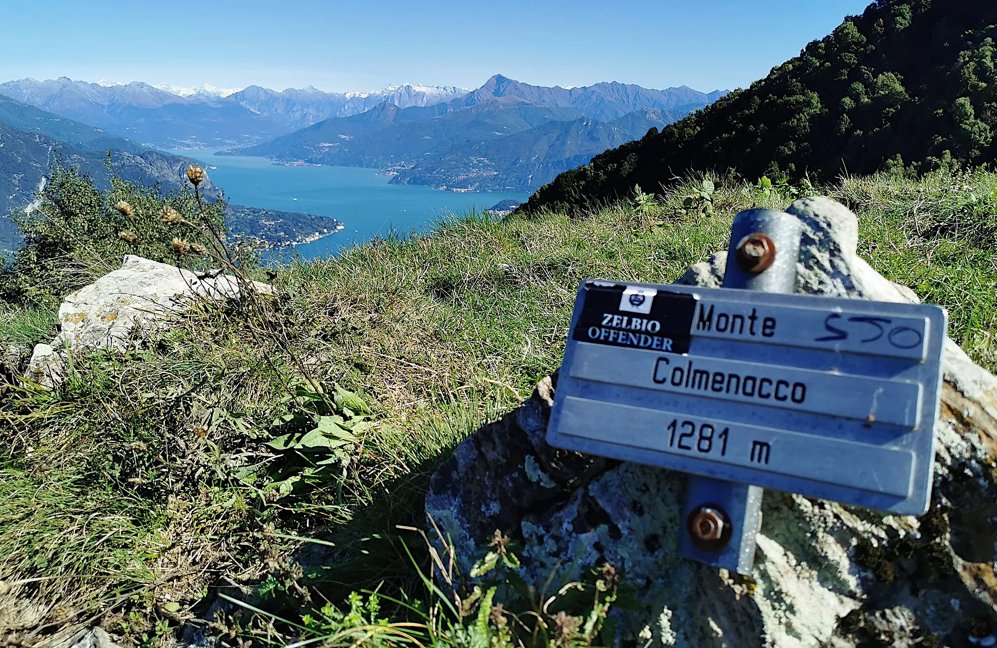 Photo showing: Cartello sulla vetta del Monte Colmenacco, sullo sfondo dell'alto Lago di Como.