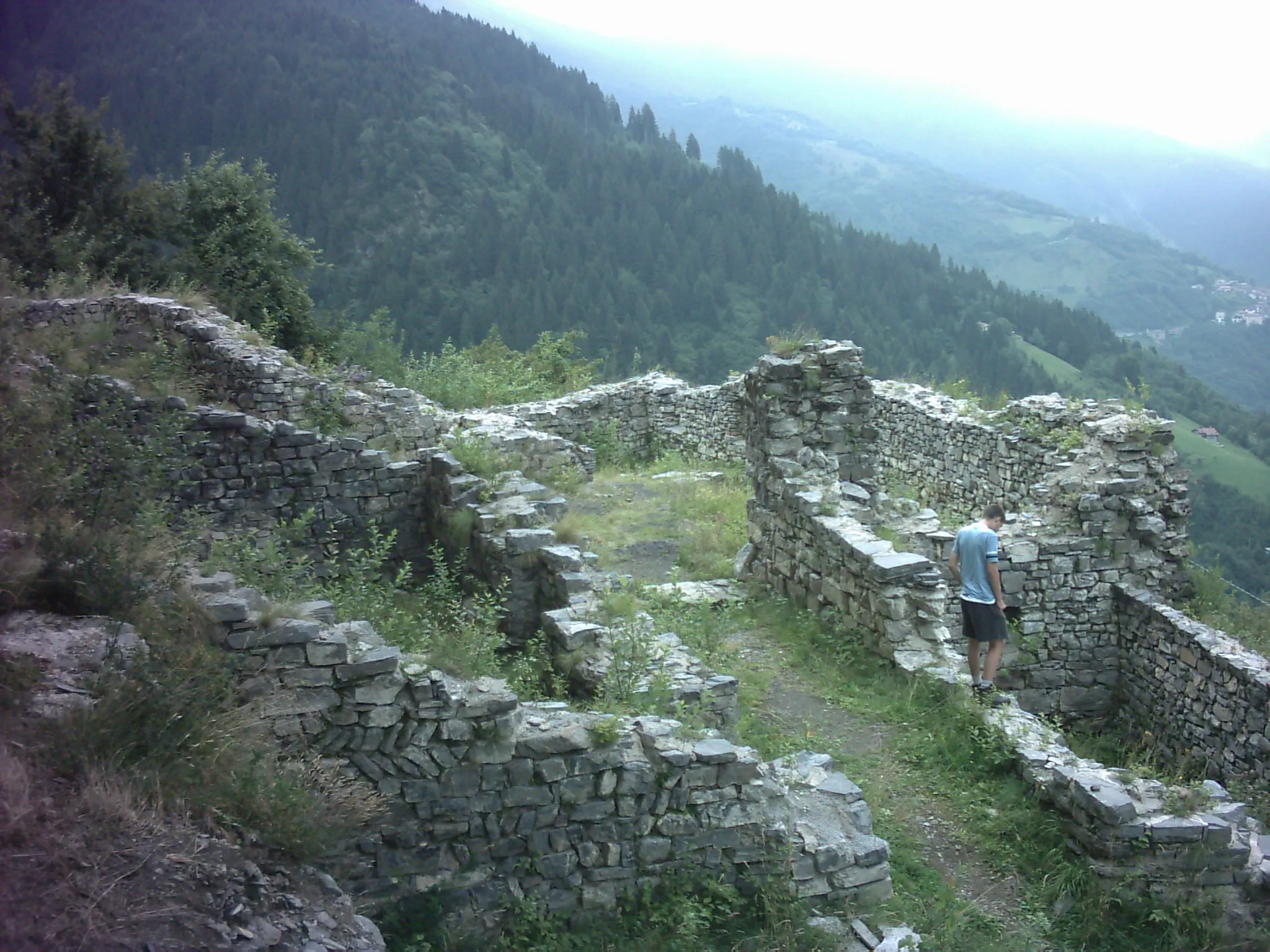 Photo showing: The desolate ruins of the ancient castle of Lozio, in the en:Val Camonica, on the top of a steep hill some 1200 metres above sea level. The castle was property of a powerful guelph family that ruled above the valley up to 15th century, Nobili. This castle was the only one belonging to Nobili family that wasn't destroyed.