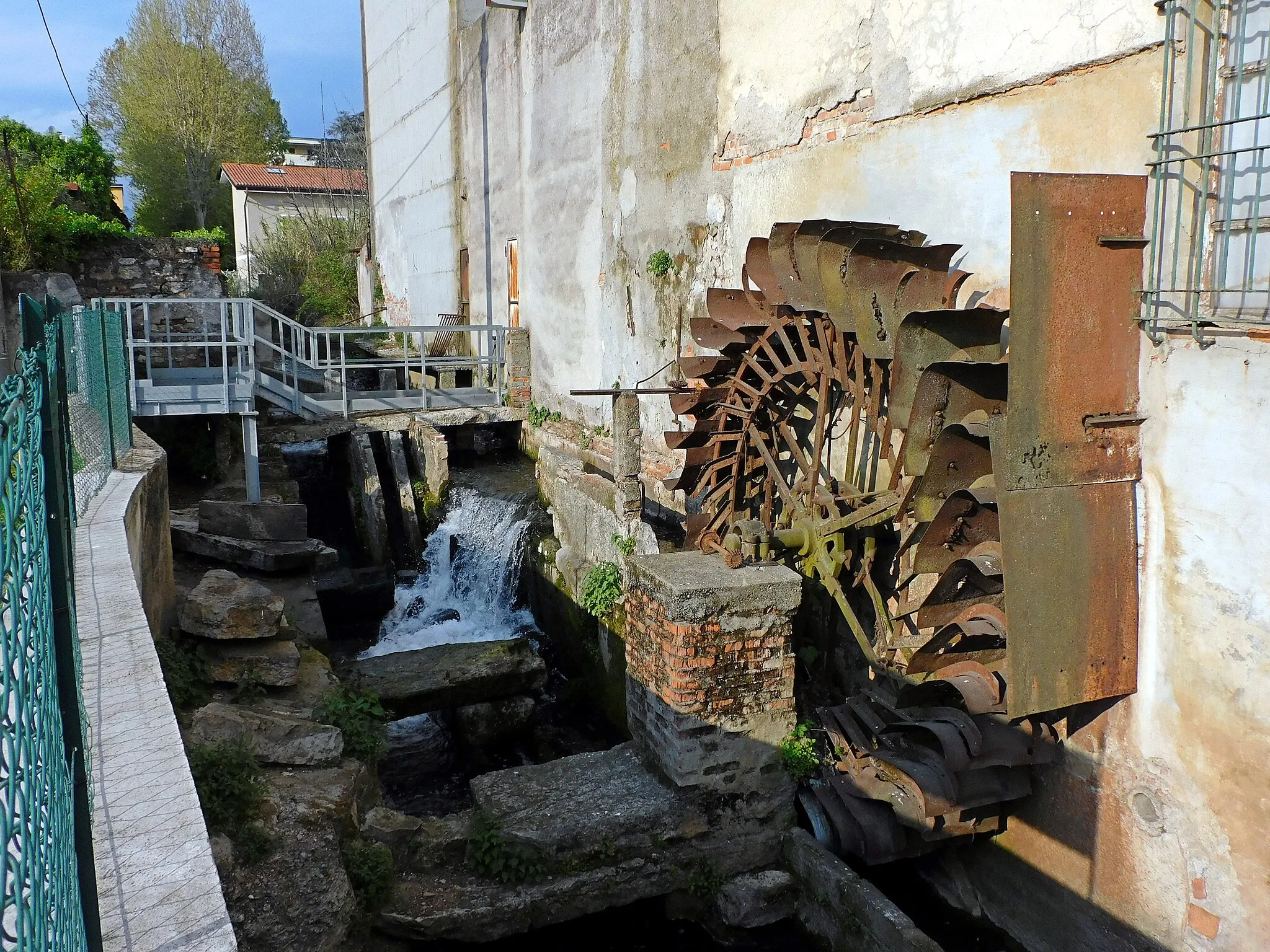 Photo showing: La ruota del mulino del quartiere Bottonaga sul Fiume Grande Superiore, restaurata nell'autunno 2021 dal comune di Brescia con la partecipazione delle associazioni «Brescia Underground» e «Amici di Bottonaga» e del «Consorzio di bonifica Oglio Mella»