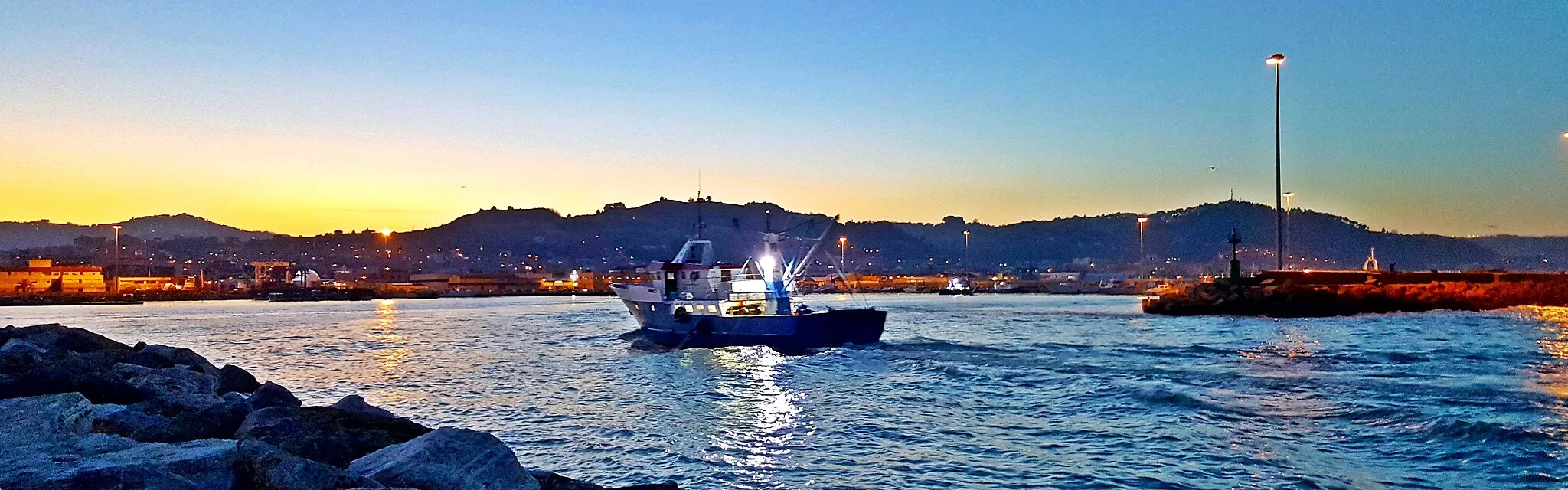 Photo showing: San Benedetto del Tronto, fishing boat returns to the port at sunset