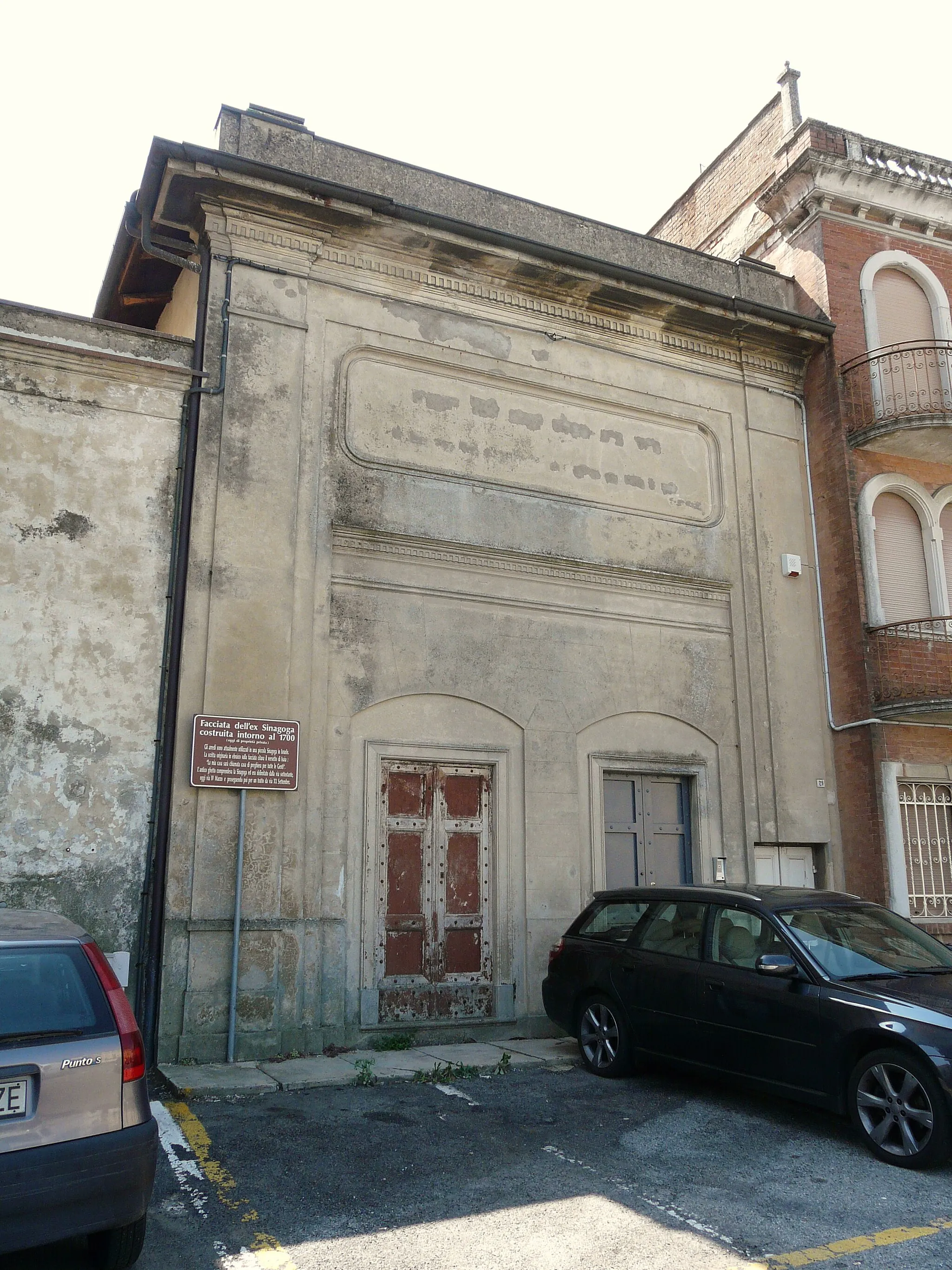 Photo showing: The former synagogue of Moncalvo, Piedmont, Italy. The information board supplies the following information. Façade of the former synagogue built around 1700, which is now in private hands. The furnishings are currently in a small synagogue in Israel. The Hebrew inscription, [with Italian translation below,] now effaced, is from Isaiah: ‘La mia casa sarà chiamata casa di preghiera per tutte le Gente’ / ‘my house will be called a house of prayer for all peoples’. The ancient ghetto included the synagogue and was delimited by the streets below: Via IV Marzo and a stretch of Via XX Settembre.