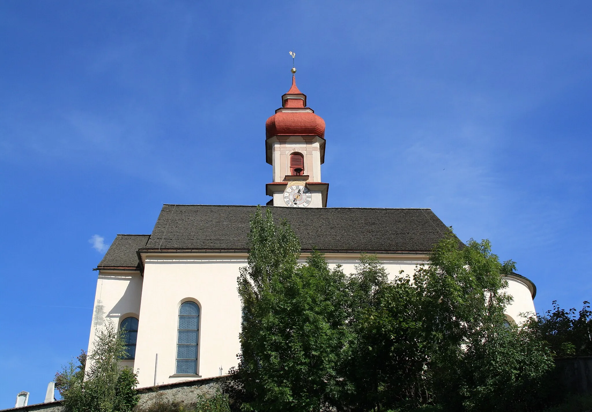 Photo showing: Italy, South Tyrol, Gossensaß. The church is dedicated to the Immaculate Conception and was built in 1750 on the same place of the old gothic church erected in 1471 and dedicated to Saint George of which remains the bell tower. The church was built on design of Franz de Paula Penz in baroque, it is possible a former project by Johann G. D. Grasmair. The church was consecrated on July 4 and 5, 1754 by bishop Leopold von Spaur. The front shows the portal of the old church and the three niches in which are placed the statues of the Immaculate Conception, Joachim and Saint Anne. The nave has a cross shape with two arms forming four lateral chapels. The high altar is rich in golden shades and at the centre of the throne is placed the statute of the Immaculate with the child. To the left side, between the two lateral chapels, is the baroque pulpit of 1777 positioned in a central site. To the right side between the two lateral chapels is a Crucifix by Bartlmä Kleinhans. The first right lateral altar is dedicated to Our Lady of Sorrows encircled by the statues of Mary Magdalene, Saint Elisabeth and Saint James works of 1750. The second right lateral altar is dedicated to Francis Xavier and two Bishops: Saint Ingenuinus and Saint Albuin coming from the old Saint George church. The first left lateral altar is the Flagellation of Christ at the column and the Saints Peter and John on each side. To the second left lateral altar is Saint Leonard, by side are the statues of Saint Sylvester, Saint Gregory and Saint Barbara coming from the old church. The eastern dome fresco was painted by Matthäus Günther and represents the Christ crowning Mary and Saint George throwing the pierced dragon downwards.