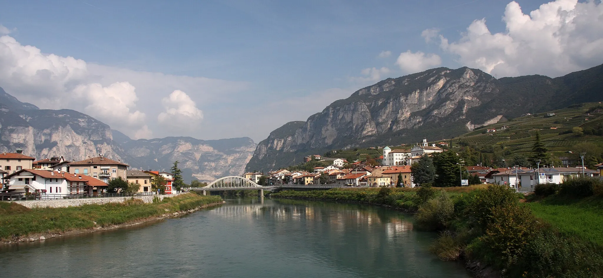 Photo showing: The town of en:San Michele all'Adige (TN), Italy, view from the south taken from the new pedestrian bridge over the Adige river. On the left side (right bank) of the river is frazione Grumo, while on the opposite side is San Michele proper.