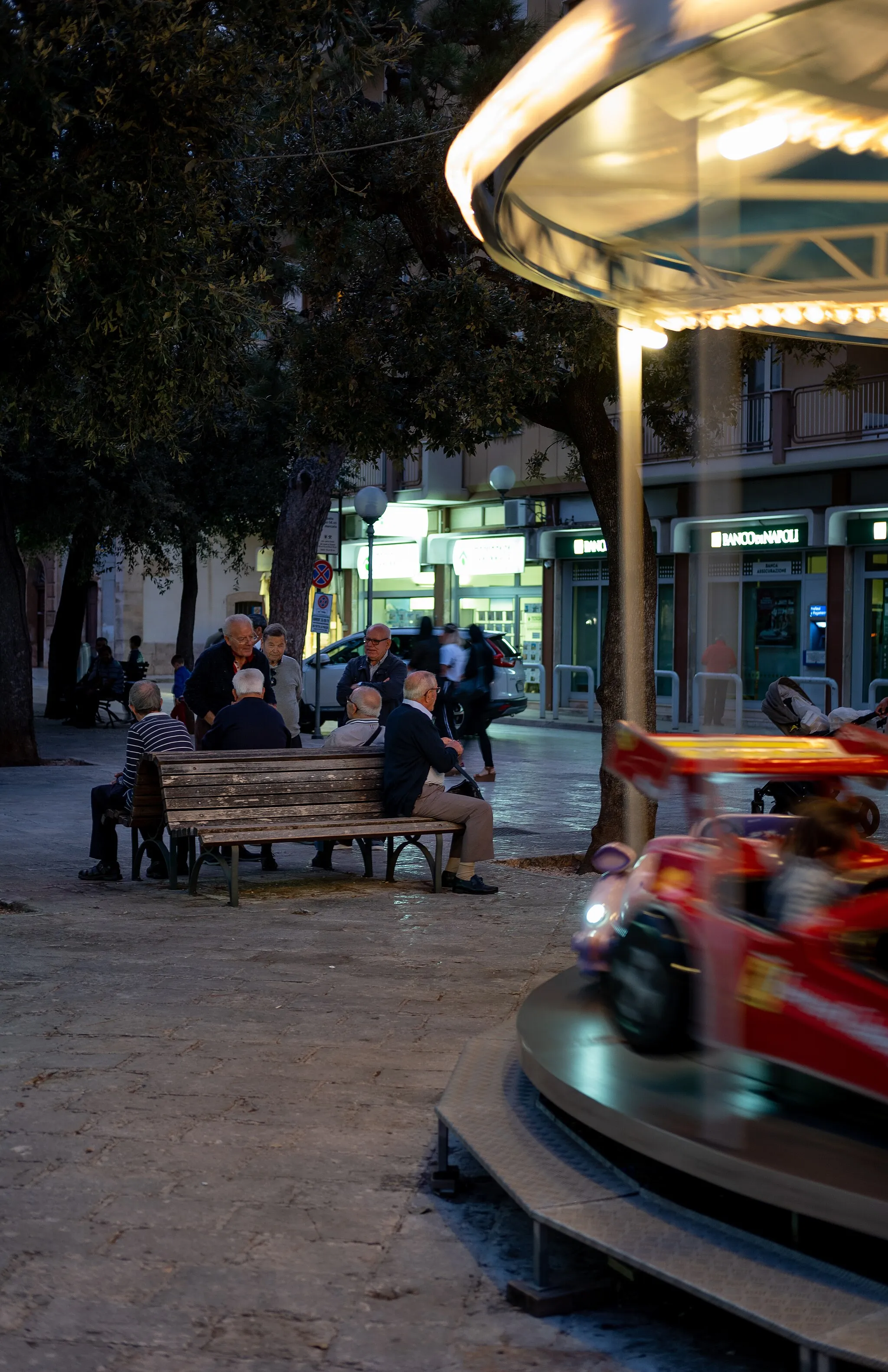 Photo showing: Old men sitting by a carousel, Castellana Grotte, Italy (PPL1-Corrected)