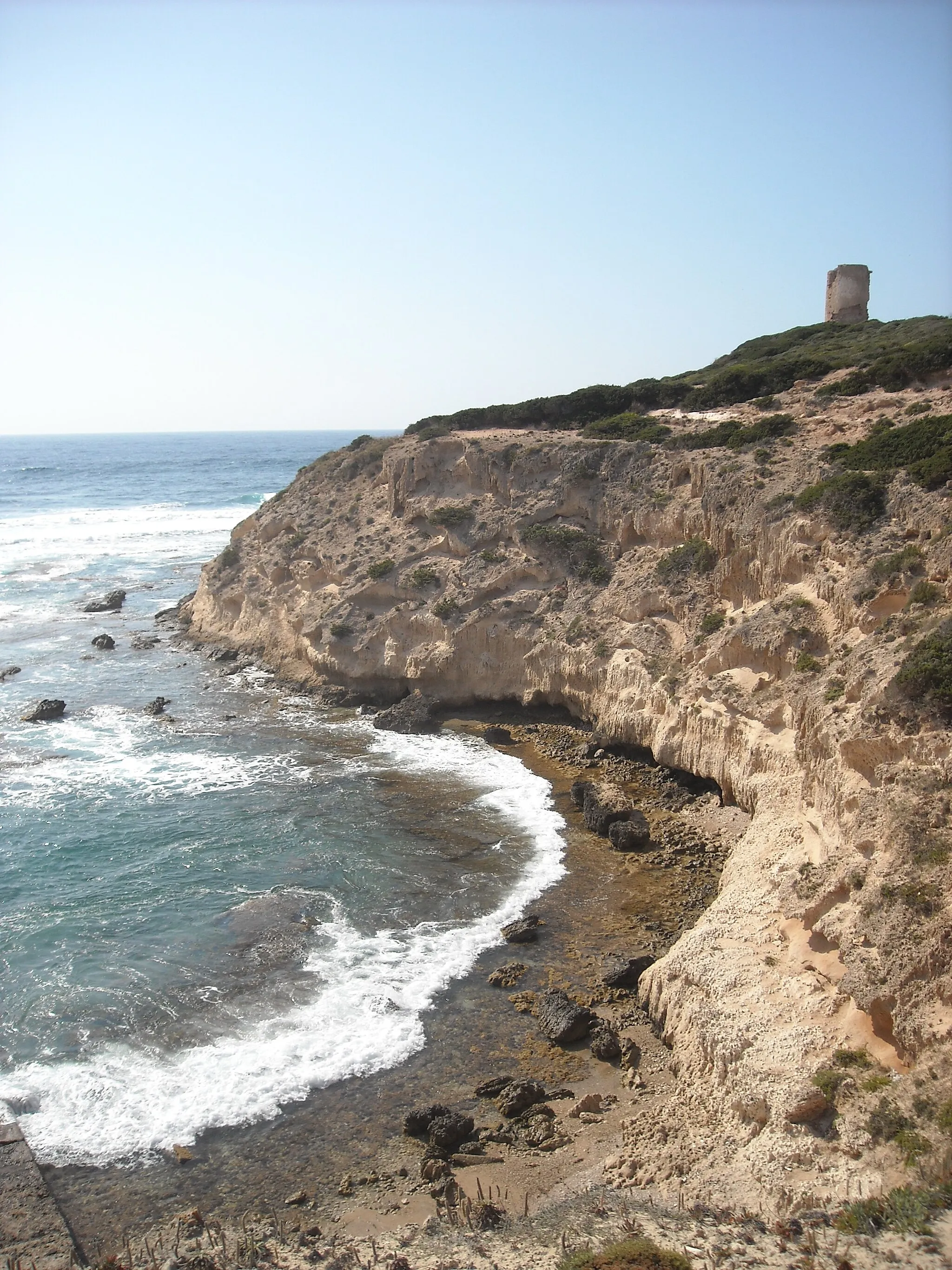 Photo showing: Scogliera di Capo Mannu con torre aragonese, nella penisola del Sinis, Sardegna