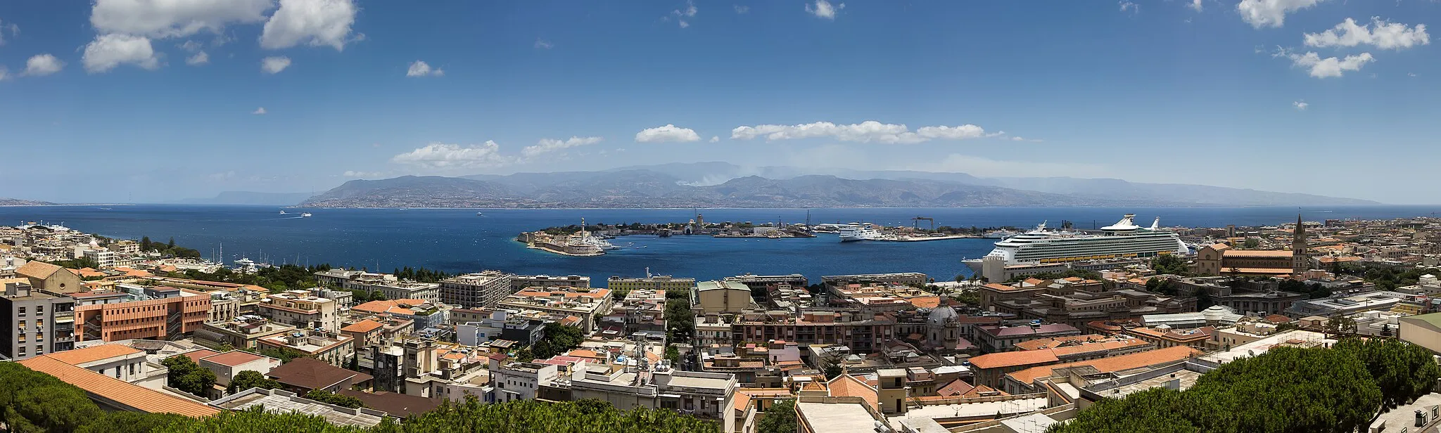 Photo showing: Messina Strait seen from Messina towards the Italian Mainland
Panorama 1/320sec at f/8 ISO 100 EF-S 15-85 f3.5-5.6 IS USM at 28mm
The Strait of Messina (Stretto di Messina in Italian, Strittu di Missina in Sicilian) is the narrow passage between the eastern tip of Sicily and the southern tip of Calabria in the south of Italy. It connects the Tyrrhenian Sea with the Ionian Sea, within the central Mediterranean. At its narrowest point, it measures 3.1 km (1.9 mi) in width, though near the town of Messina the width is some 5.1 km (3.2 mi) and maximum depth is 250 m (830 ft).
A ferry service connects Messina on Sicily with the mainland at Villa San Giovanni, which lies several kilometers north of the large city of Reggio Calabria; the ferries hold the cars (carriages) of the mainline train service between Palermo and Naples. There is also a hydrofoil service between Messina and Reggio Calabria.
The strait is characterized by strong tidal currents, that established a unique marine ecosystem. A natural whirlpool in the Northern portion of the strait has been linked to the Greek legend of Scylla and Charybdis. In some circumstances, the mirage of Fata Morgana can be observed when looking at Sicily from Calabria (Wikipedia)

Best view: press "L"