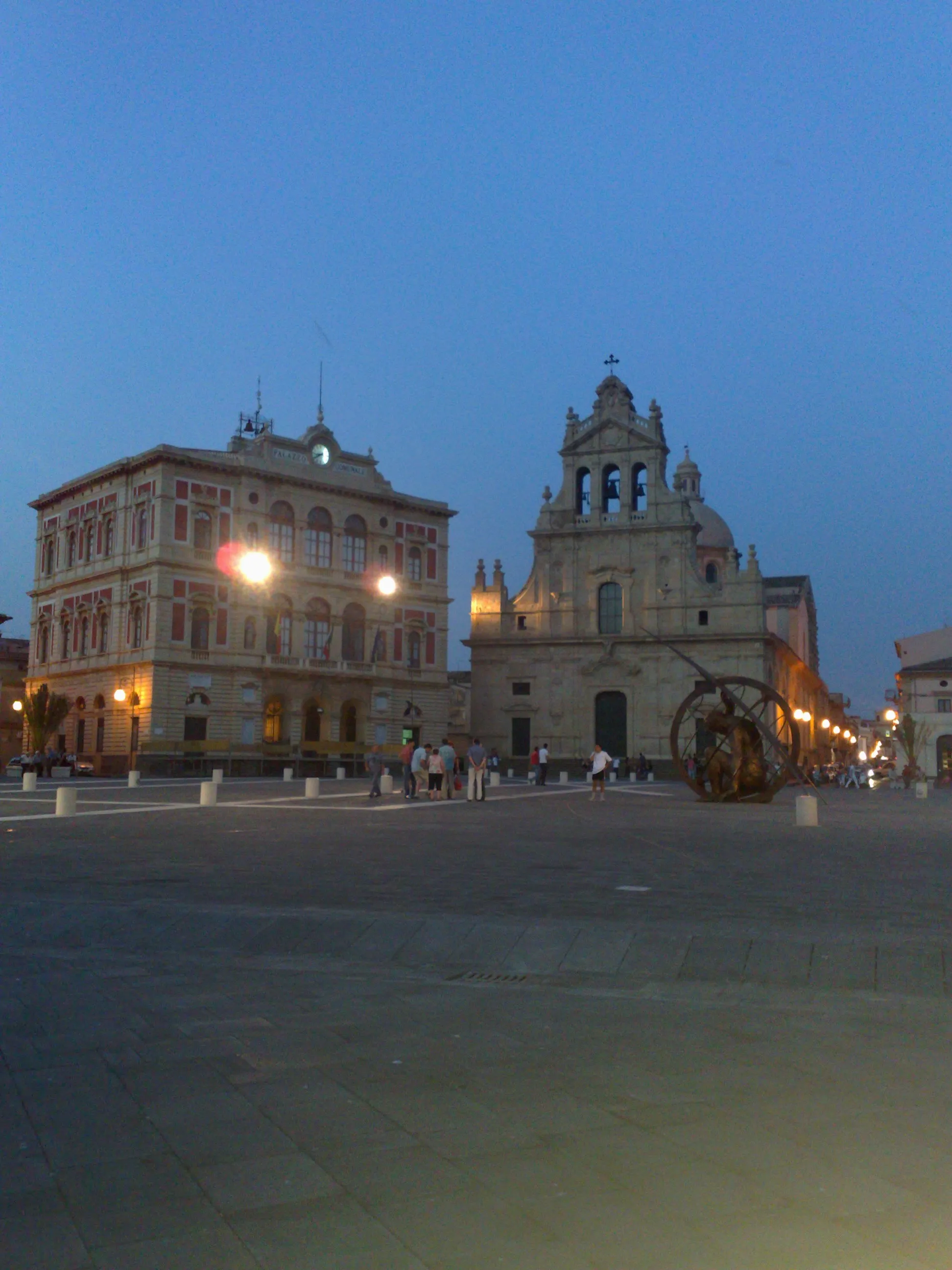 Photo showing: The beatiful public square of Grammichele, a small city in the province of Catania. In the photo the town hall, the cathedral and the new sundial.